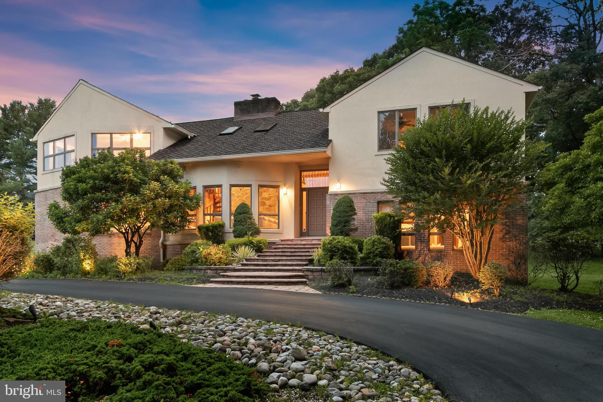 Welcome to your private retreat in one of the area’s most sought-after communities! This one-of-a-kind custom home offers a truly unique living experience that will make you feel like you are on vacation every day. Featuring five bedrooms and three full bathrooms spread across four thoughtfully designed levels, this home provides generous space, flexibility, and privacy for every lifestyle. Nestled on over 4 acres of beautifully landscaped grounds that back to woods, this setting offers tranquility and seclusion while still being conveniently located near everything you need. From the moment you step inside, you are greeted by soaring two-story vaulted ceilings with wood planks, skylights, and an abundance of natural light throughout. The main level features an impressive front living room with a stacked-stone fireplace that is double-sided and shared with the kitchen, creating a warm, welcoming ambiance. A wet bar area off the living room is perfect for entertaining guests. The expansive eat-in kitchen is a chef’s dream, fully equipped with stainless steel appliances, granite countertops, ample storage space, and a dining area with access to the deck that overlooks the backyard and woods. Completing this level is a laundry room with a pantry and access to the two-car garage. Upstairs, the primary bedroom suite is a true escape with a cathedral ceiling, a luxurious en-suite bathroom that includes a jetted tub and walk-in steam shower, along with a large walk-in closet and dressing vanity area. Three additional bedrooms and a second full bathroom complete the upper level. A few steps down from the foyer, the lower level includes a spacious family room and a fifth bedroom with a door to the third full bathroom. A versatile bonus room on this level is ideal for an office, playroom, or even another bedroom. Down a few more steps, the basement level provides even more flexibility with a recreation room and a large office with built-ins. A large utility room adds more storage space. Enjoy spending time outside on the spacious deck with an expansive backyard that has space for everyone’s outdoor activities. Don't miss this rare opportunity to own a spectacular property that combines architectural distinction with a serene, resort-like atmosphere. Additional highlights include zoned heating and cooling systems, two water heaters, and a generator.