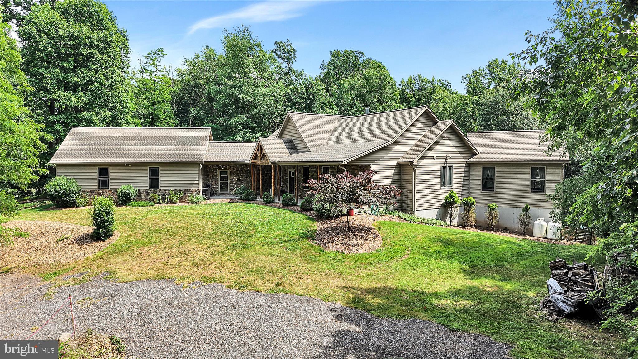 Nestled on a sprawling 11.37-acre lot, this exquisite Post & Beam residence offers a harmonious blend of luxury and comfort in a serene rural setting. Built in 2012, the home showcases a stunning architectural design that invites warmth and sophistication, making it the perfect retreat for those seeking an exclusive lifestyle. Step inside to discover an expansive 4,490 square feet of meticulously finished living space. The open floor plan seamlessly connects the gourmet kitchen, complete with upgraded countertops, a spacious island, and stainless steel appliances, to the inviting dining area. The living area is enhanced by exposed beams and a cozy wood fireplace, creating an inviting atmosphere for relaxation. Natural light floods the space through energy-efficient double-hung windows, highlighting the rich hardwood flooring throughout. The main level also boasts a luxurious primary suite with a walk-in closet and an opulent bathroom featuring a soaking tub and a walk-in shower, providing a private sanctuary for rejuvenation. Venture downstairs to the fully finished daylight basement, which offers additional living space and an outside entrance, perfect for guests or recreational activities. The exterior of the property is equally impressive, featuring a personal in-ground pool surrounded by a beautifully landscaped deck and patio area, ideal for summer gatherings or tranquil evenings under the stars. The property is adorned with exterior lighting and floodlights, ensuring safety and ambiance. Additional highlights include a three-car attached garage with rear entry, ample parking on the asphalt and gravel driveways, and a charming bank barn that adds character to the estate. The lush, wooded surroundings provide a sense of privacy and seclusion, allowing you to immerse yourself in nature while enjoying the comforts of modern living. This remarkable home is not just a residence; it's a lifestyle. The barn has been constructed with the same detail, quality and thought as the home, with wood beams, insulated with heat and C/A and a half bath. Lots of storage and potential office space. Experience the tranquility of rural living while being just a short drive from urban conveniences. Embrace the opportunity to make this luxurious haven your own, where every detail has been thoughtfully curated for your comfort and enjoyment.