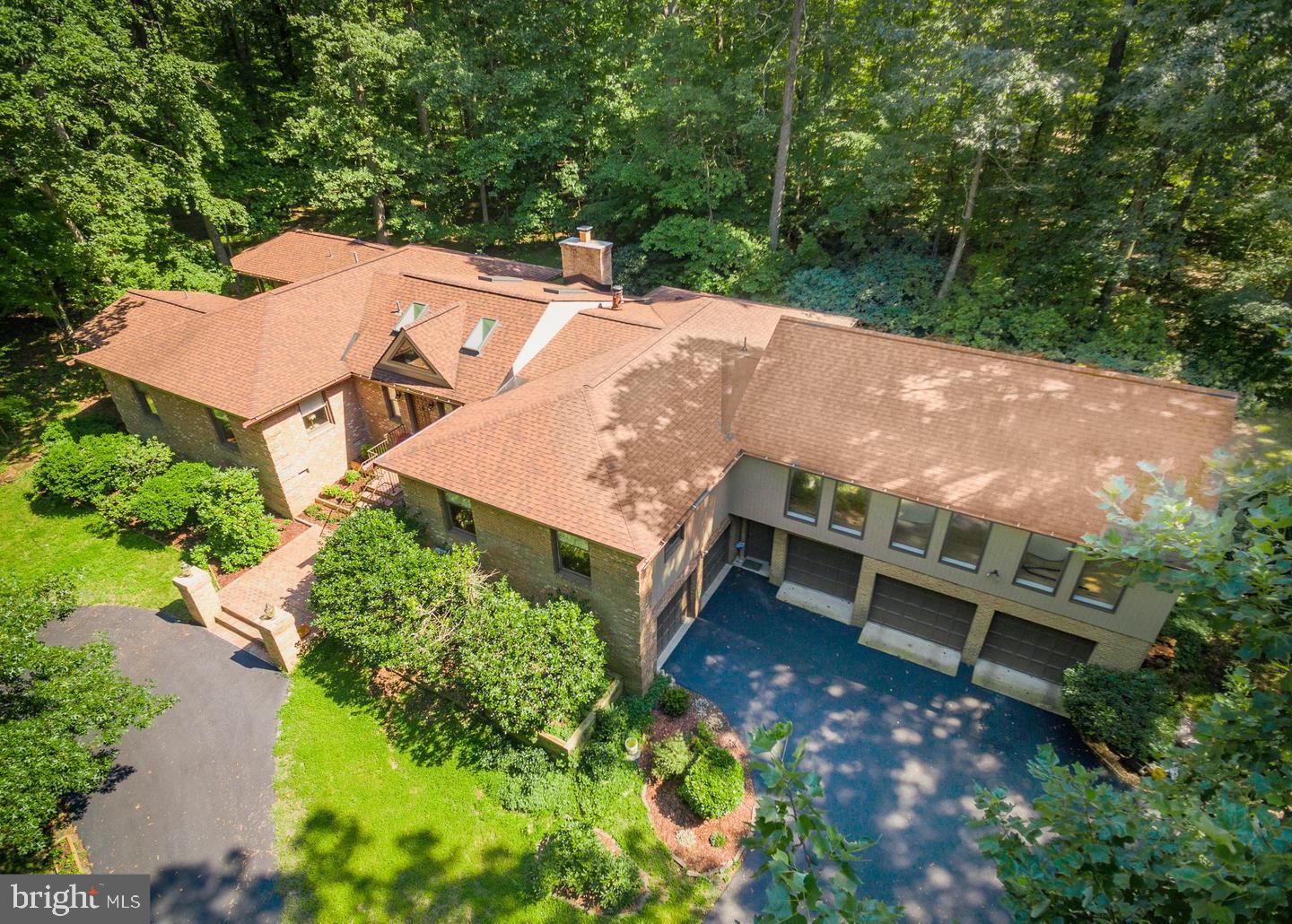 Unique and elegant contemporary residence offers 5000 sq ft of living space and an open floor plan that appreciates the love of nature on a secluded 3½ acre lot. This home includes a wing of four bedrooms and four bathrooms, in addition to two powder rooms.  Vaulted ceilings and an open floor plan allow for an abundance of dramatic light to fill the home.  The great room provides three sides of floor-to-ceiling windows and a Carrara marble fireplace.  Chefs will enjoy the gourmet kitchen, featuring state-of-the-art appliances, limestone counters and custom cabinetry.  The lower level provides a spacious office that walks out to the garden, a powder room, and two garages.  There is expansive decking that spans the width of the home and is accessible from most rooms.  Enjoy all the seasons in this custom designed house that brings the outdoors in.