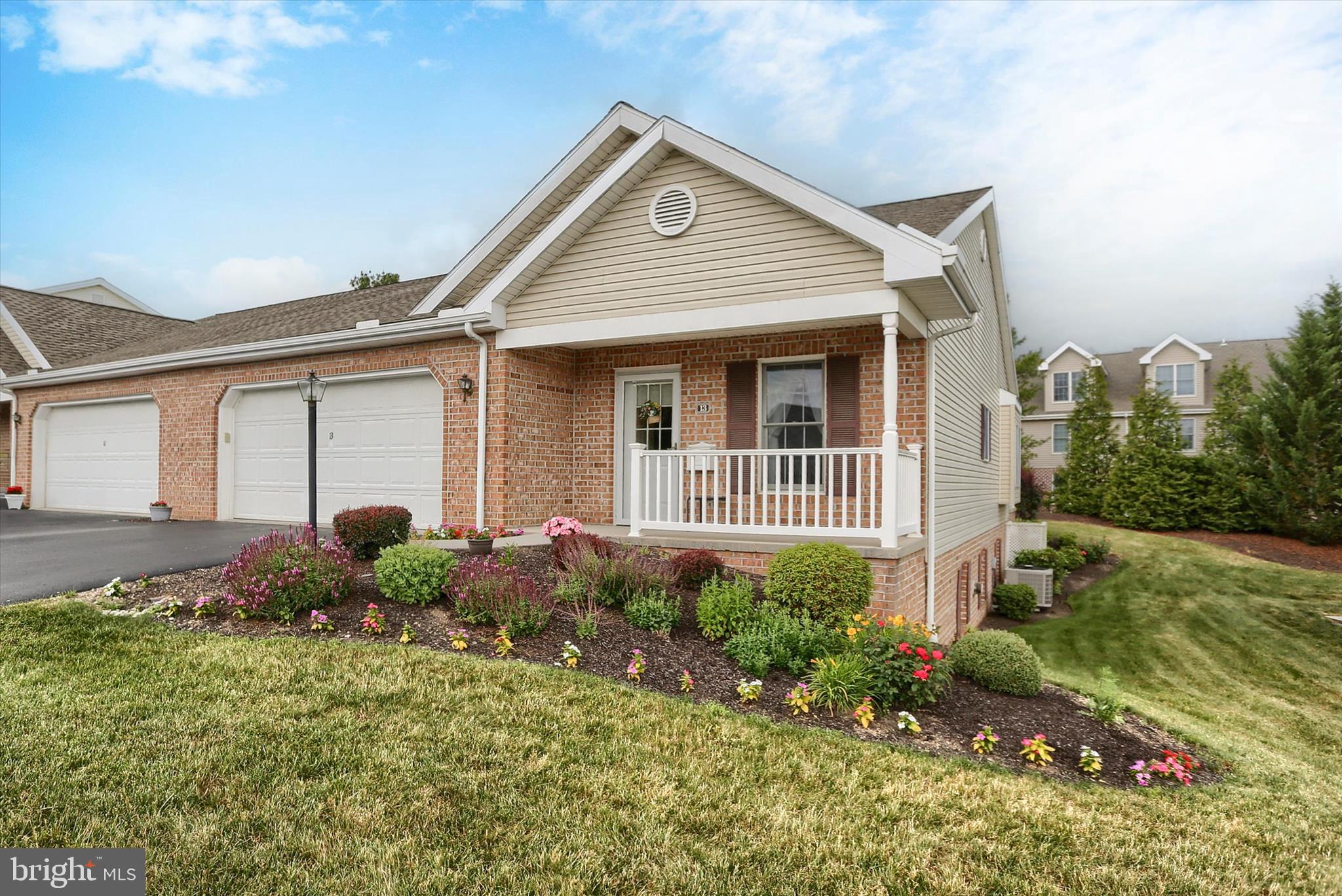 Welcome to this beautifully maintained end-unit home in the sought-after 55+ community of Bent Creek Crossing. Lovingly maintained by the original owners, this beautiful home offers 2 bedrooms, 2 full baths, Hunter Douglas window treatments and an impressive list of thoughtful upgrades throughout.  Step inside to discover a neutral palette, butter-textured ceilings, crown molding, and plush Karastan carpeting in the inviting living room. The well-appointed kitchen features fine Italian porcelain tile flooring, expansive solid-surface countertops with an eating bar, Houzer double sink, recessed lighting, newer KitchenAid stainless steel appliances, and a vented range hood—perfect for everyday living and entertaining alike. The adjoining dining area is filled with charm, showcasing luxury vinyl plank flooring, chair rail detailing, Tiffany-style lighting, custom window treatments, and a large window with a built-in window seat overlooking the side yard. A French patio door provides easy access to outdoor living.  The spacious primary bedroom offers plush Karastan carpet, a walk-in closet and an updated ensuite bath featuring a custom tiled walk-in shower with grab bars and waterfall glass doors, a Kohler toilet, and a soapstone-topped vanity & Moen fixtures. A generously sized second bedroom includes double closets and is conveniently located near the second full bath, which also boasts a custom tiled walk-in shower, Kohler toilet, soapstone countertop & Moen fixtures.  The full basement provides endless possibilities with 9-foot ceilings, abundant storage space, room for future finished living areas, hobbies, or a workshop, wash basin and grinder pump sump pump. A 35,000 BTU propane heater adds additional comfort year-round.  Additional updates include heat pump (2018) and a roof replacement completed approximately in 2024, offering peace of mind for years to come.  Ideally located just minutes from shopping, restaurants, hospitals, major highways, and everyday amenities, this exceptional home combines quality craftsmanship, comfort, and convenience. Whether you're enjoying morning coffee and the views on the covered front porch or relaxing on the rear patio, you'll appreciate everything this property has to offer.  Don't miss your opportunity to call this beautiful home your own!