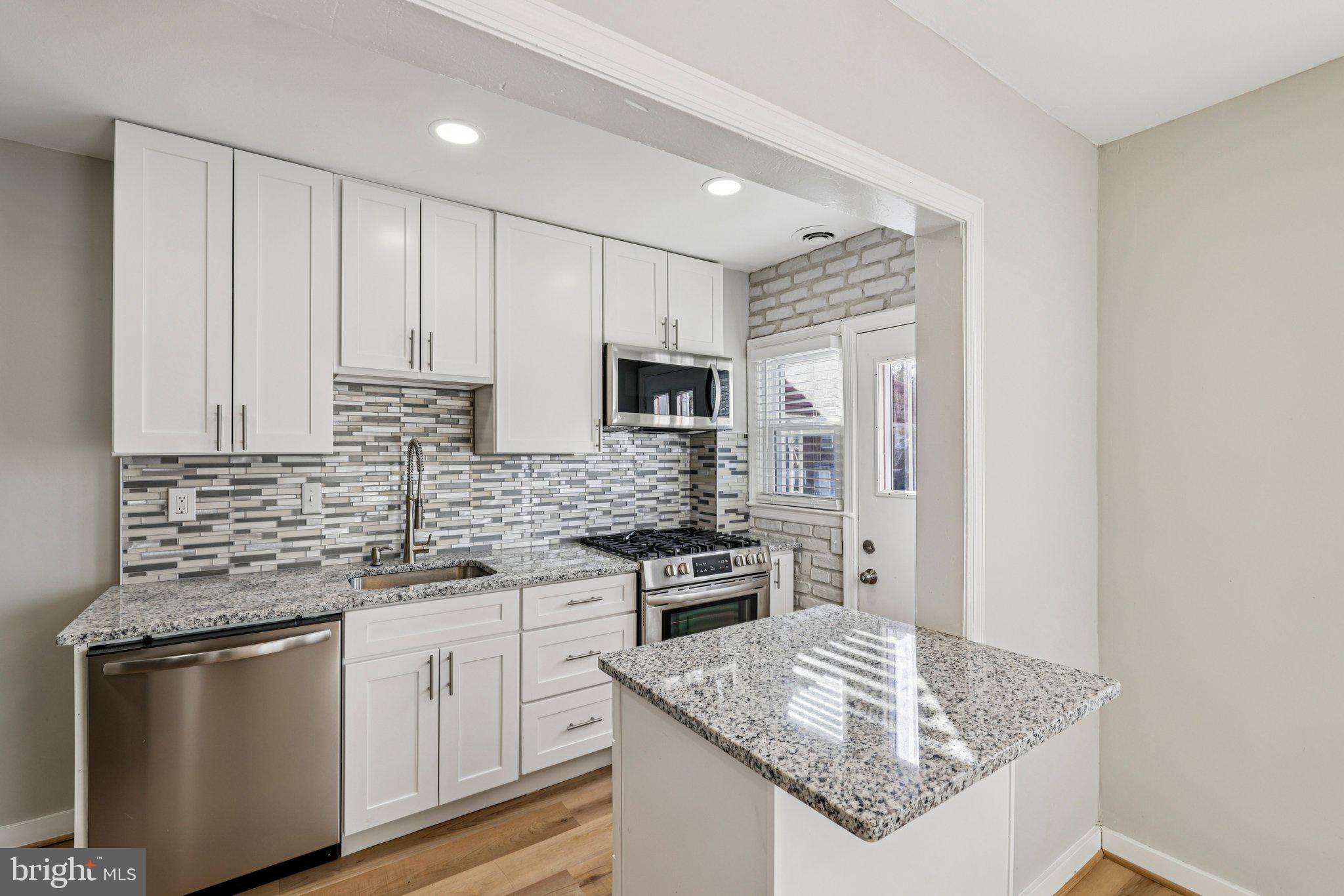 BRAND NEW ROOF (June 2026) AND UPGRADED ELECTRIC (June 2026) -  Fully Renovated 4BR/2BA Brick Rowhome! This updated and upgraded home features a modern kitchen with granite countertops and an island, hardwood floors, and a fully finished basement with a private 4th bedroom and full bath. The rear basement entrance leads to a level, fenced-in backyard—perfect for entertaining. Relax on the covered front porch or enjoy the comfort of central A/C. Quiet neighborhood location with easy access to commuter routes and transit. ROOF (less than 3 years old), Water Heater replaced in 2024, HVAC (less than 5 years), Kitchen renovated in 2025, and fireplace insert installed in 2025. Move-in ready and priced to sell!  Select photos for this listing have been virtually staged.