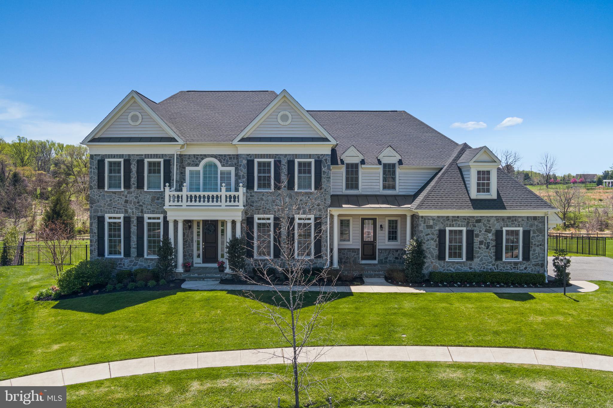 This absolutely exquisite home will be your own slice of paradise that is sure to provide endless comfort and relaxation for many years to come. Stately and picturesque and settled upon a meticulously maintained lot that measures over .6 acres, this exceptional home is truly meant to be yours. Make your way into the bright entry foyer, where a unique tray ceiling and elegant wainscoting make for a distinguished appearance. Formal living and dining spaces offer room for entertaining and feature an airy, open design.
                At the center of the main level stands the kitchen, absolutely stocked with impressive function and features. Sparkling granite counters, stainless steel appliances, abundant cabinet space, a massive 13’ center island (with room for casual dining!), an oversized walk-in pantry, an expansive gas range, four ovens (two of which are built-in wall ovens), and so much more make this an absolute chef’s dream. Enjoy the adjacent sunlit breakfast area and convenient access to the mud room and garage. A gracious, cozy family room is just steps away, perfectly punctuated by a fireplace and with an open sight line from the kitchen to allow for breezy entertaining.
                Continue up the stairs to the upper floor, which begins with a unique landing area and flows into a total of four bedrooms. The owner’s suite is uniquely appointed with a gracious sitting area and luxurious en-suite bath with a free-standing soaking tub,  enormous shower stall with a seat, double vanities, and dressing area. Each secondary bedroom features its own walk-in closet and accommodating en-suite bath (second and third bedrooms have a Jack & Jill bath). The laundry is conveniently situated on the upper level to make life a little simpler.
                The lower level has been finished and awaits your enjoyment with its extra-large recreation room, fifth bedroom with an en-suite bath, flex room, second kitchen, storage area, and utility room.
                Finally, your private oasis awaits in the backyard, home to the truly fabulous heated saltwater pool, only just installed in 2021. No detail has been left undone across this private retreat, with features that include a sun shelf with an umbrella holder, a retractable remote-controlled awning, and an extensive paver pool deck. A gorgeous covered pavilion is centered around the stone fireplace with a cozy seating area just in front of it, offering the perfect spot for cooler evenings with friends while the sun sets.
                This home is absolutely perfect in every way, from its numerous updates to its generous fixtures, and is ready and waiting for you to call it your own.