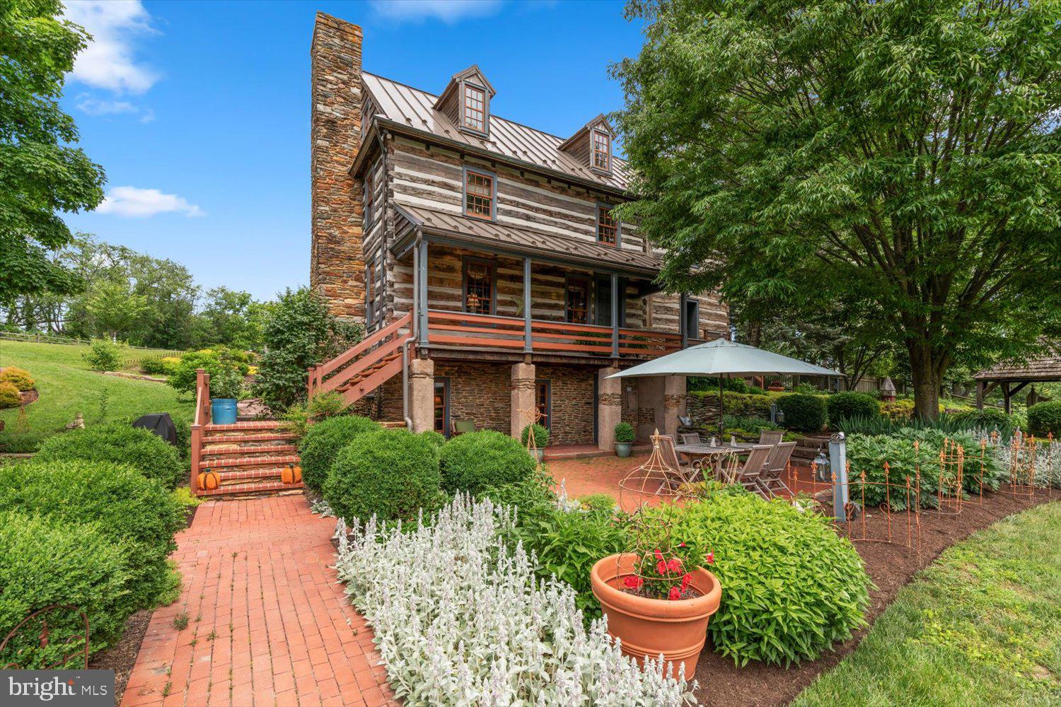 If you’ve been looking for a unique one-of-a-kind home with unmatched modern luxury and charm, and sitting on top of 10 acres of scenic Lancaster County farmland views, then stop your search - you’ve found home! Welcome to 3646 Meadow View Road in Manheim. A truly breathtaking Log Home that has been beautifully and thoughtfully renovated inside and out. The original home was built in 1800 at a different site, but was re-built at the present location in the 1990s on a modern foundation. Since then, the current owners have made some incredible upgrades and improvements during their ownership, including purchasing an adjacent parcel of land to increase the total acreage, qualifying for significantly lower taxes in the Clean and Green program, rebuilding the entire 3rd level (adding 2 bedrooms and a full bathroom), completely renovating the main-level kitchen with high-end Viking appliances and custom inset cabinetry, soundproofing the basement family room and 2nd kitchen, adding a sweeping rear screened-in porch (which could be finished for additional space in the future), installing an absolutely stunning multi-level Koi pond complete with relaxing and beautiful waterfalls, and so much more! There’s no shortage of attention to detail inside this beautiful home and from the moment you step inside, you’ll see the charm and preserved character that only a home of this caliber can showcase. The main level features a beautiful entry foyer, spacious living room with wood-burning fireplace, a dining area and the adjacent thoughtfully renovated kitchen space mentioned earlier. You’ll also find a huge screened-in porch off the rear of the home on the main level, which could easily be finished for additional living space, though you may find it a great way to relax and enjoy the sights and sounds of your property and the nearby Koi Pond. Going up to the 2nd level, you'll find the Primary Suite complete with bedroom and full bath with walk-in shower. The Primary Suite also features built-in closets with a sitting area and a wood-burning fireplace for those cozy nights or for a little ambiance. Additionally on this level you’ll find another spacious bedroom suite complete with its own full bathroom. On the 3rd level, the current owners completely renovated and structurally improved this space, adding 2 additional bedrooms and a full bathroom with claw tub and shower. The finished basement has its own unique charm, but has been brought into the modern world. A separate walk-out entrance to the basement level could allow for an in-law suite/separate living quarters as the basement itself also features a full bathroom, bedroom, kitchen area, laundry, and family room! The basement has also been soundproofed to prevent sound penetration to the rest of the house, so it could also make for a fantastic home theater space as well. The rest of the house has been modernized with a central vac system on all levels, 2 geothermal HVAC units controlling different parts of the house independently (but without the noisy outside condensers!), and built-in sound system through most of the home. While the inside is modern luxury meets old-world charm, the outdoor space will allow you to relax and soak in that country living. The home is completely fenced in from front to back, which is great for kids and pets with plenty of yard to roam around, but there’s far more acreage down the slopes to give you meadow views. Mature, established gardens surround the property and are sure to please. There are so many wonderful features about this home to highlight, but we’ll just say to schedule your showing today before it’s too late!