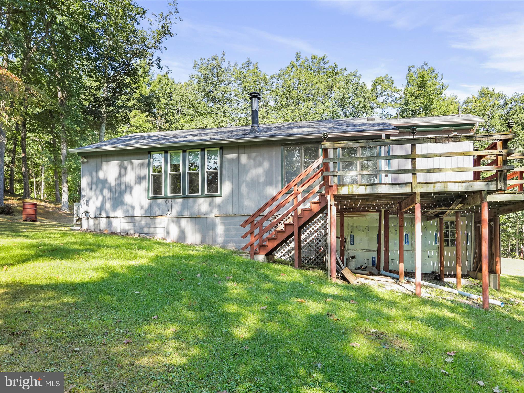 Charming and well-maintained ranch-style home situated on 4.84 private acres in Hedgesville. This 2-bedroom, 2-bath property offers a peaceful setting with recent updates throughout. 
The kitchen features luxury plank flooring and Formica countertops. Carpeted living room provides a cozy space for relaxation, while the dining/sunroom offers additional living space and leads to a rear deck—perfect for entertaining or enjoying the outdoors. 
Primary bedroom includes an attached full bath. Mini-split system provides efficient heating and cooling. Additional features include a new roof, newer windows, and a wood stove installed just one year ago. 
Ample outdoor space for gardening, recreation, or future expansion. Convenient to local amenities while offering privacy and tranquility. 
Don’t miss this opportunity—schedule your showing today!