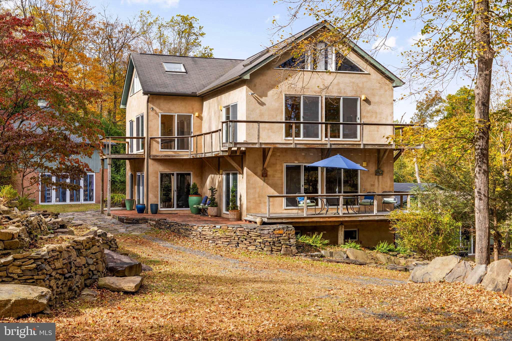 A rare Bucks County property offering endless possibilities for creative living, extended family, or entrepreneurial ventures. Set on a hillside with panoramic views of nature and seasonal glimpses of the Delaware River, this unique estate includes multiple residences with flexible spaces ready to inspire. The Main House is a modern and spacious 3-bedroom home with sweeping views — a peaceful retreat overlooking the river valley. The Carriage House contains a garage and studio above. The Gable House is a charming 2-bedroom dwelling full of character that is income producing or could be used for extended family and guests. The Barn House is a versatile building featuring income producing studio apartment and a 2-bedroom apartment — ideal for rentals, workspaces, or artist residencies. With so many living options, the property is well-suited for multi-generational families, collaborative households, or those seeking live/work flexibility. Artists and entrepreneurs will find abundant space to create, host, or generate income.
It's just a short walk to the Delaware River and the riverside village of Point Pleasant, with direct access to the towpath for biking and hiking. Nearby, enjoy the vibrant cultural scenes of Frenchtown, NJ, New Hope, PA, and Doylestown, PA.
Commute time is under 2 hours to NYC, 80 minutes to Philadelphia, and 50 minutes to Princeton — making this the perfect retreat or full-time residence for those looking to blend work, creativity, and lifestyle.