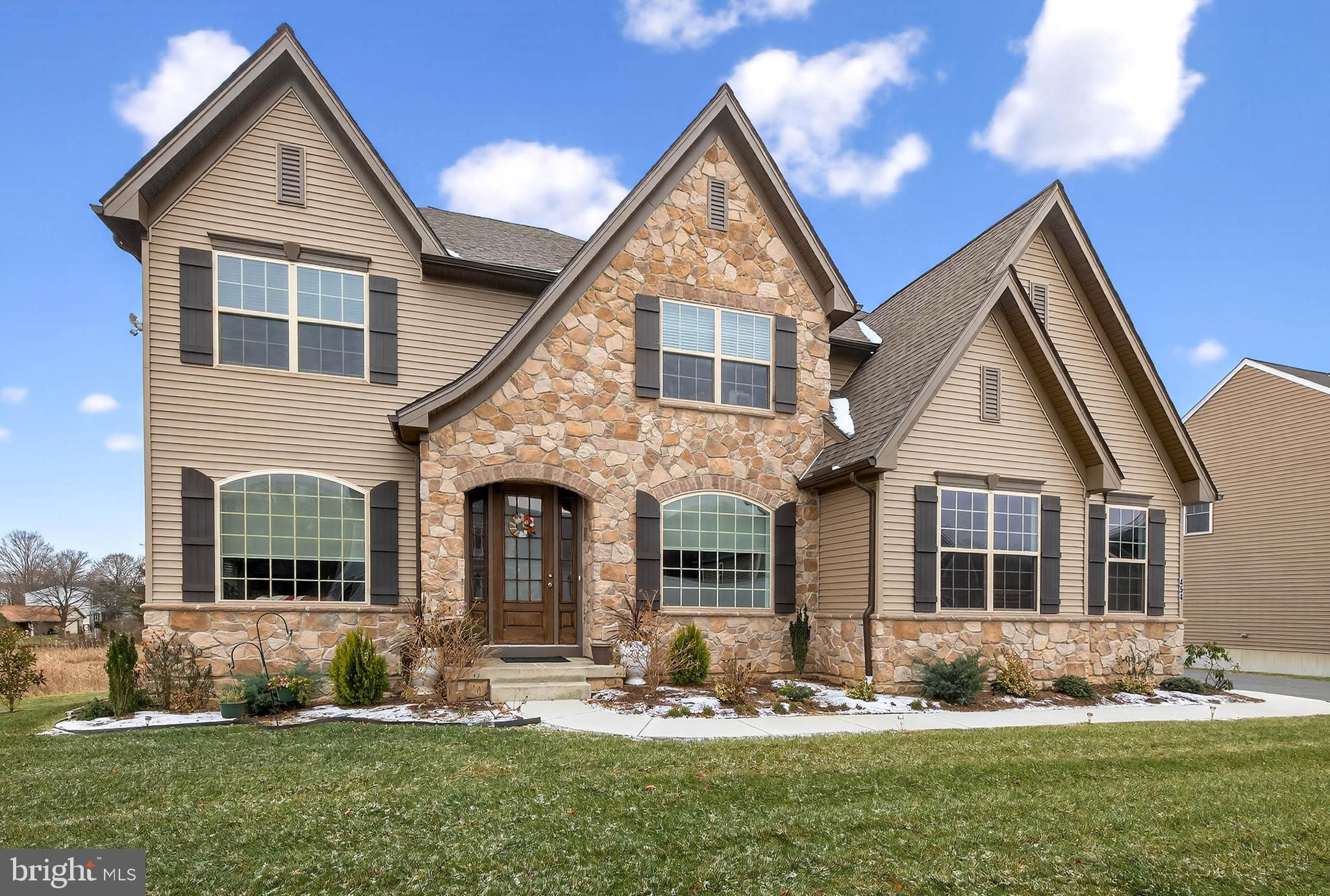Welcome home to 454 E Delp Rd, Lancaster, PA, an impressive and thoughtfully designed corner-lot residence offering expansive living spaces, abundant natural light, and a flexible layout ideal for everyday living and entertaining.

Enter through the front door into a striking foyer featuring recessed lighting, large windows, and luxury vinyl plank flooring that extends throughout most of the main level. A stunning curved staircase serves as a true architectural focal point, wrapping gracefully around elegant pendant lighting and leading to the second-story loft above. To the right of the foyer, the formal dining room is filled with natural light and accented by refined pendant lighting, creating an inviting setting for gatherings.

The dining room flows seamlessly through a butler’s/walk-in pantry with beautiful built-ins and generous counter space (walk-in pantry custom made by Closet by Design), leading into the breathtaking open-concept kitchen—the heart of the home. The kitchen features an oversized granite-topped island with stainless steel sink, matching stainless steel Whirlpool appliances, abundant, soft-closing cabinetry and built-ins, generous, granite-topped counter space, tile flooring, and a sunny breakfast nook. The kitchen also offers direct access to the rear deck, complete with a gas hook-up for grilling and a utility sink, extending the living space outdoors.

Just off the kitchen, the great room makes a dramatic statement with soaring 20+ foot ceilings, walls of windows that flood the space with natural light, luxury vinyl plank flooring, and a gas fireplace with mantle. Upper windows are equipped with power-controlled Bali blinds (that come with a lifetime warranty), adding both convenience and comfort. Heading back toward the kitchen, the main-level suite offers a walk-in closet (custom made by Closet by Design) and a private en-suite full bath with a tub/shower combination. A conveniently located half bath sits just across the hall near the secondary staircase entrance.

The second level is accessible via either of the home’s two staircases and opens to a spacious loft overlooking the great room, kitchen, and foyer below. From the loft, access is provided to four bedrooms, a well-appointed full bath, a laundry room with washer and dryer hook-up, and a bonus storage room. Most bedrooms feature generously sized walk-in closets. One bedroom includes a private en-suite full bath with tub/shower combination. The primary suite is highlighted by a spacious en-suite bath featuring a walk-in stall shower and a dual granite-topped vanity.

An oversized 2-car garage offers bonus storage space and two powered garage doors, providing both convenience and functionality. The home is further enhanced by a full, finished walk-out basement, recently completed in September 2025, offering expansive living and storage space with carpeted flooring, abundant windows, elegant ceiling light fixtures, and paneled glass walk-out doors. The lower level also includes a bonus bedroom with walk-in closet and an additional full bath with a tub/shower combination, adding valuable flexibility to the home.

Outdoor features include a beautiful backyard with established gardening areas and raised garden boxes ready for seasonal planting. The yard has been recently seeded and shaped for ease of access and enjoyment. Additional exterior features include three hose hookups on separate sides of the home and motion-detecting flood lights. The property is located in a quiet, tranquil neighborhood with convenient access to Oregon Pike and no HOA.

With 37 windows (all equipped with high-quality cordless blinds, except the higher-up, automatic ones), this home is filled with natural light from every angle and offers an exceptional blend of space, design, and everyday practicality. 454 E Delp Rd, Lancaster, PA presents a rare opportunity to enjoy a well-appointed home with versatility, comfort, and timeless appeal.