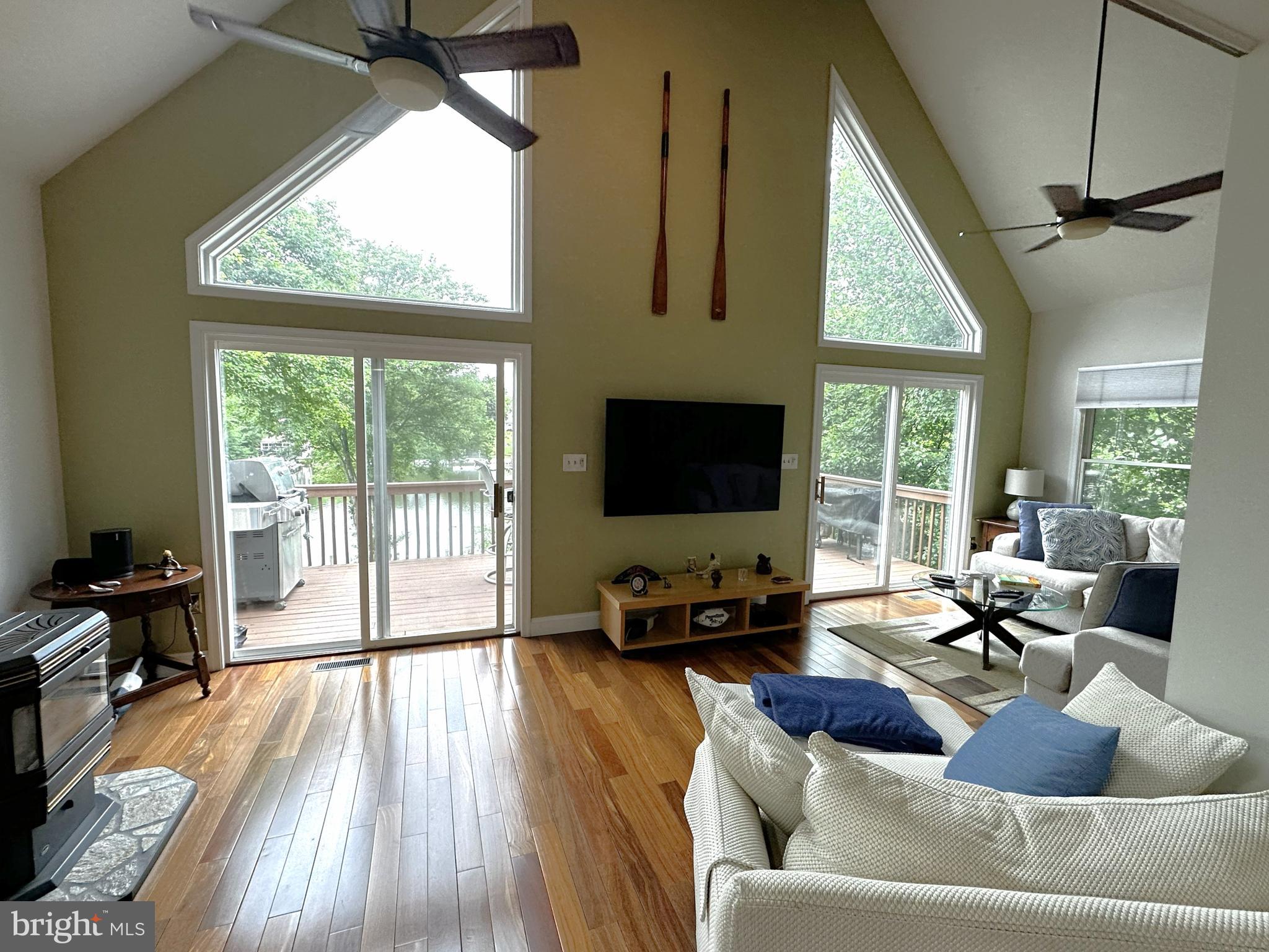 Wake up each morning to shimmering water views and the peaceful feeling of life on the Chesapeake Bay in this beautifully updated custom waterfront retreat, originally built in 1994 and thoughtfully enhanced with modern upgrades and timeless finishes. This exceptional home offers the perfect blend of comfort, warmth, privacy, and waterfront lifestyle.
From the moment you enter, the soaring two-story living room draws you in with expansive windows, rich solid teak hardwood floors, a cozy pellet stove, and breathtaking views stretching across Long Cove. Double sliding glass doors invite the outdoors in, opening to spacious decks where morning coffee, sunset dinners, and quiet evenings by the water become part of everyday life. Extensive landscaping surrounds the home, creating a lush and inviting setting, while generous off-street parking for up to six vehicles makes entertaining family and friends effortless.
The gourmet kitchen is designed for gathering, featuring beautiful Silestone counters, a large island, dining area, and GE Profile stainless appliances — all positioned to keep the water always within sight. Upstairs, the luxurious primary suite feels like a private waterfront retreat with cathedral ceilings, rich teak hardwood floors, a balcony landing overlooking the dramatic living area below, and breathtaking panoramic water views. The spacious en-suite bath offers a spa-like experience with a double vanity, whirlpool soaking tub, and separate shower — the perfect place to relax and recharge after a day on the water.
Friends and family will love the fully finished lower level with its large entertaining bar, game room, half bath, walkout access, and easy connection to the backyard and pier. Outside, your private pier with 12,500 lb boat lift and additional slip makes spontaneous days on the water effortless, while the rare privacy created by neighboring double lots gives the property an unusually peaceful and secluded feel.
Beyond the property itself, the voluntary community association enhances the lifestyle with amenities including a private boat ramp, beach, pier, playground, and clubhouse — creating the perfect setting for boating, swimming, fishing, neighborhood gatherings, and enjoying everything waterfront living has to offer.
Whether hosting summer gatherings on the deck, boating at sunset, or simply relaxing while watching the water change with the seasons, this home offers the kind of everyday waterfront experience most people only dream about — all within convenient reach of Annapolis, Baltimore, Washington, DC.  and BWI Airport