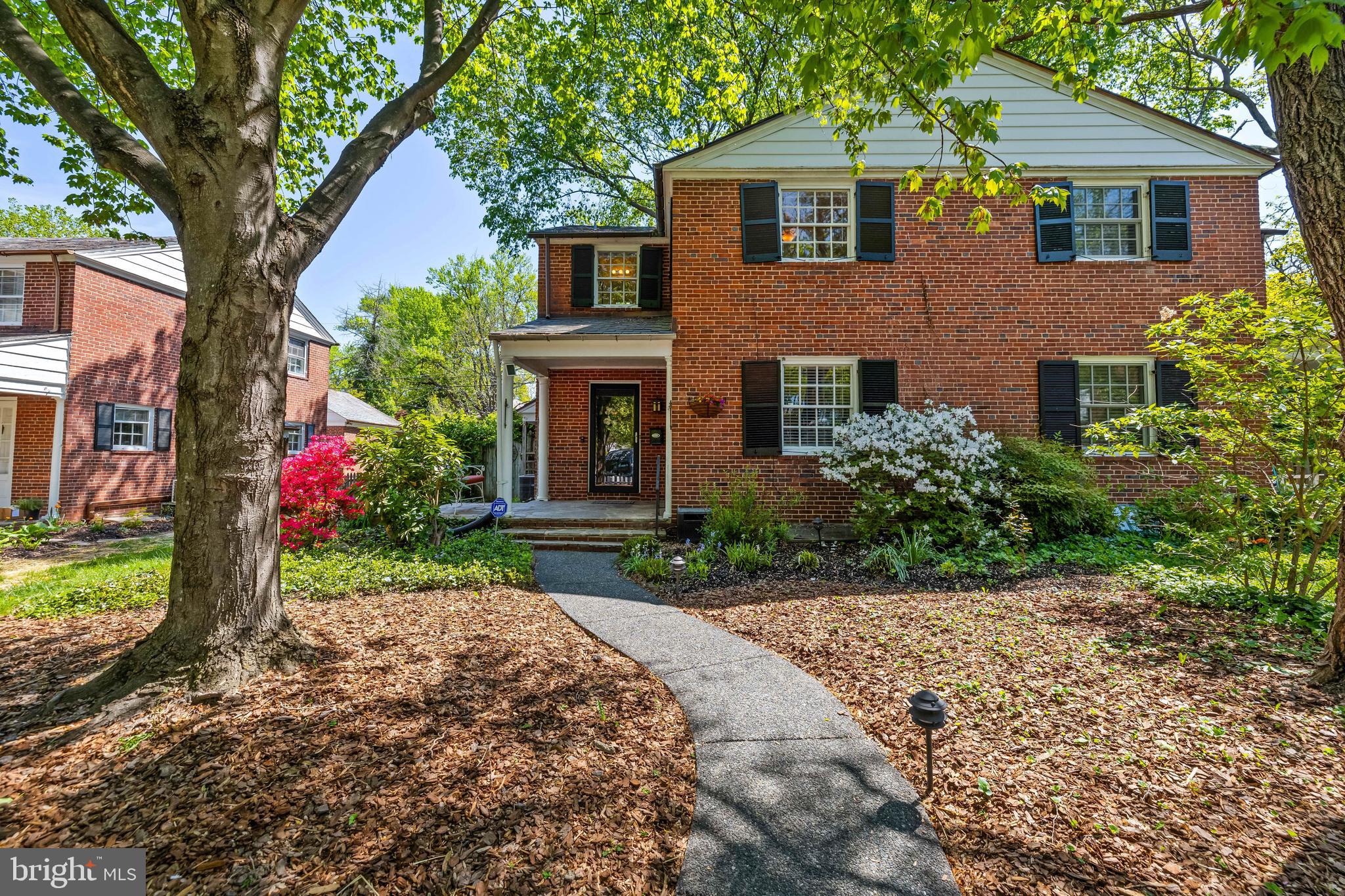 Brimming with care and pride of ownership, this charming semi-detached Colonial is nestled on a beautifully tree-lined street at the end of a quiet cul-de-sac in the coveted Homeland neighborhood. Surrounded by perfectly manicured garden beds, flowering shrubs, and mature trees, the setting is as picturesque as it is peaceful. Just moments from the Homeland Lakes, this home offers the perfect blend of tranquil surroundings and walkable convenience. Step inside to discover a sun-drenched front sunroom, complete with rich hardwood floors and a wood-burning fireplace, ideal for morning coffee or curling up with a good book. The formal dining room features gleaming hardwoods, classic wainscoting and chair rail detailing, creating an inviting space for memorable gatherings. The kitchen flows effortlessly from the dining area, making entertaining both easy and enjoyable. Upstairs, you'll find three spacious bedrooms, a freshly re-glazed full bath, and ample closet space throughout. The finished lower level offers newly installed flooring, generous storage, and a second full bath. The area is perfect for a guest suite, rec. room, or home office. Step outside to your private backyard retreat with two charming paver patios, an ideal setting for al fresco dining or winding down with an evening drink. Bonus area in the back could be used for a fire pit or outdoor entertaining under the stars. Additional highlights include a detached garage, whole-house interior paint (2025), beautifully refinished hardwood floors (2025), updated basement vanity and flooring (2025), new washer/dryer (2024), new refrigerator (2022), main house slate roof replacement (2014), PVC sewer line replacement, and more. Truly a delightful home in an unbeatable location!