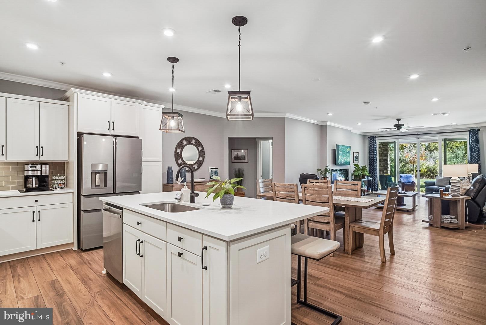 A price improvement has been made, making this unit the best value in the entire community. This home shows like a model with approximately $55,000.00 in upgrades. No need to wait for new construction this unit is ready for immediate occupancy.  Love Where You Live! Experience resort-style living that blends comfort, luxury, and convenience—just steps from the waterfront.  Enjoy peaceful mornings without the disruption of construction nearby.  This highly sought-after first-floor condo is move-in ready and has been meticulously maintained, featuring numerous upgrades throughout. Step inside to an open, light-filled layout enhanced by crown molding, recessed lighting, and direct views of the lush greenspace with seasonal water glimpses. The gourmet kitchen and dining area are ideal for entertaining, offering a spacious island with seating, quartz countertops/bar, sleek wifi enabled appliances, and seamless flow into the living room. Unwind by the cozy fireplace or open the double sliding glass doors to your private patio—perfect for watching the sunrise, morning coffee, reading, or simply enjoying the peaceful natural setting. The owner’s suite offers both a walk-in and secondary closet, private patio access, and a luxurious en-suite bath with dual sinks and a spa-inspired frameless glass shower. The guest suite is bright and spacious, complete with its own en-suite bath, custom tilework, and large vanity. A bonus room with upgraded frosted glass doors provides the perfect space for a home office, workout area, or reading nook.  Additional highlights include:  LVP flooring throughout the entire home, interior access to a private one-car garage, and a secure storage unit.  From your patio, take a stroll along the walking trail where you can take in the sights and sounds of nature to discover tranquil views and your kayak launch.  The community also has direct access to the Kent Island Cross Island Trail. Many extra amenities to enjoy including an indoor heated pool, outdoor infinity pool, firepits, pickleball and tennis courts, dog park, and beautiful walking and biking trails.  Live every day like you’re on vacation—this stunning condo offers the lifestyle you’ve been waiting for and is a must see to experience all of the upgrades! Water and sewer fees are already included in the owners monthly COA.