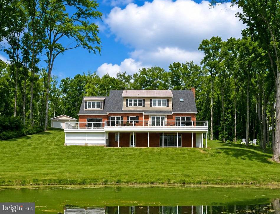 Price improvement! Wait until you see this! Impecably maintained brick house on nearly 20 acres, overlooking a pond with tons of privacy. 2 large outbuildings. High-end upgrades and fixtures. The house has 4 bedrooms and 3.5 baths.  A primary owner's suite on the main floor and an additional owner's suite on the second floor.  Beautiful hardwood floors throughout.  The main floor features a bar room and an office.  Kitchen with marble countertops and a huge professional refrigerator.  Fully finished basement.  2 car attached garage. The first outbuilding is a office space with 2 private offices, a conference room, a gym, kitchenette and half bath.  The second outbuilding features 5 garage bays and a finished area that serves as a family room with kitchenette. This property is nothing short of spectacular.