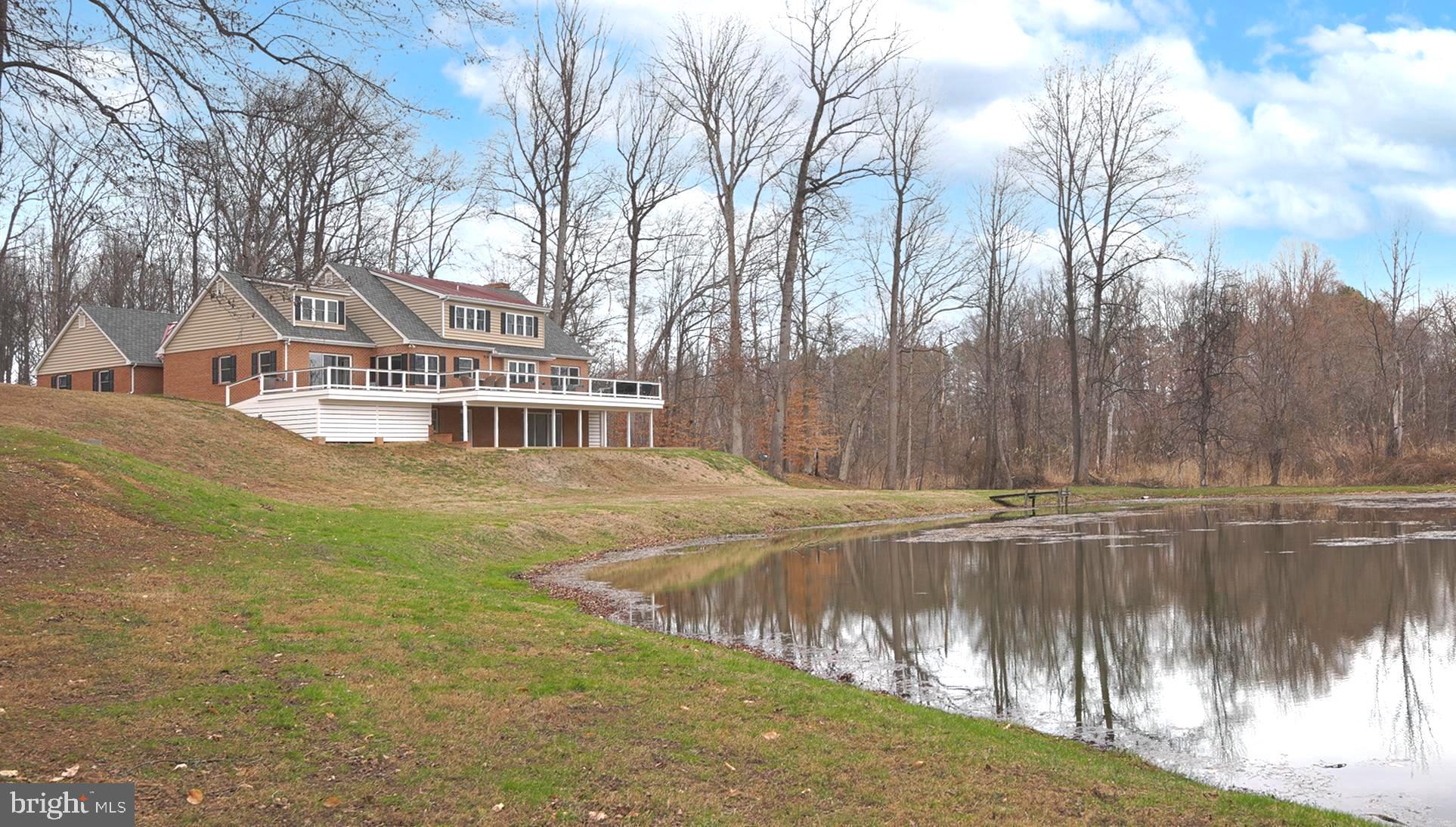 Wait until you see this! Impecably maintained brick house on nearly 20 acres, overlooking a pond with tons of privacy. 2 large outbuildings. High-end upgrades and fixtures. The house has 4 bedrooms and 3.5 baths.  A primary owner's suite on the main floor and an additional owner's suite on the second floor.  Beautiful hardwood floors throughout.  The main floor features a bar room and an office.  Kitchen with marble countertops and a huge professional refrigerator.  Fully finished basement.  2 car attached garage. The first outbuilding is a office space with 2 private offices, a conference room, a gym, kitchenette and half bath.  The second outbuilding features 5 garage bays and a finished area that serves as a family room with kitchenette. This property is nothing short of spectacular.