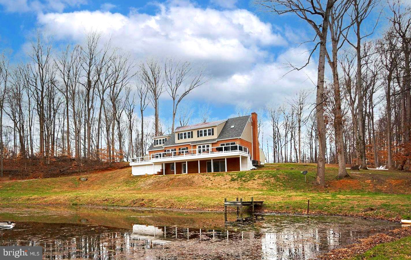 Wait until you see this! Impecably maintained brick house on nearly 20 acres, overlooking a pond with tons of privacy. 2 large outbuildings. High-end upgrades and fixtures. The house has 4 bedrooms and 3.5 baths.  A primary owner's suite on the main floor and an additional owner's suite on the second floor.  Beautiful hardwood floors throughout.  The main floor features a bar room and an office.  Kitchen with marble countertops and a huge professional refrigerator.  Fully finished basement.  2 car attached garage. The first outbuilding is a office space with 2 private offices, a conference room, a gym, kitchenette and half bath.  The second outbuilding features 5 garage bays and a finished area that serves as a family room with kitchenette. This property is nothing short of spectacular.
