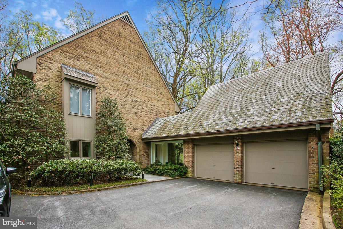 Tucked within the prestigious Merrywood on the Potomac enclave, this elegant all-brick residence offers a rare blend of timeless architecture, gracious scale, and exceptional privacy in one of McLean’s most coveted settings. A stately landscaped approach and classic brick façade create a striking first impression, setting the tone for the beautifully appointed interiors within.
Spanning over 6,500 finished square feet, this home showcases sun-filled, generously proportioned living spaces designed for both sophisticated entertaining and comfortable everyday living. A welcoming foyer opens to expansive formal and informal rooms enhanced by rich architectural details, soaring ceilings, and walls of windows that frame serene, tree-lined views. A dramatic four-level spiral staircase and an oversized elevator provide both visual impact and modern convenience, while refined finishes, classic brick construction, and a slate roof underscore the home’s enduring quality.
The stunning living room serves as a central gathering space, offering exceptional volume, abundant natural light, and seamless access to a balcony overlooking the pool area, through full-length sliding glass doors—creating a harmonious connection between indoor and outdoor living. A formal dining room provides an elegant setting for entertaining with an abundance of recessed lighting, and extra built in cabinets. The dining room is complemented by a butler’s pantry that flows effortlessly into the bright, spacious kitchen overlooking the private patio. The kitchen features generous counter space, a central island, and picturesque views, making it ideal for both daily living and hosting.
Just beyond the kitchen, a private patio retreat provides the perfect setting for al fresco dining or quiet relaxation, surrounded by mature landscaping and tranquil natural beauty. 
Thoughtfully designed for today’s lifestyle, the main level also includes a private office or library with custom built-ins, along with inviting interior walkways that adds architectural interest throughout, an attached two-car garage is complemented by an upper-level executive office, ideal for working from home.
The beautifully designed primary suite area occupies the top level, featuring inlaid hardwood flooring, abundant recessed lighting, oversized windows with blackout shades, and thoughtfully designed storage areas within the dormer spaces. The luxurious spa-inspired bath offers a five-star retreat experience. The third level includes four spacious secondary bedrooms, each with its own en-suite bath and ample closet space.
The walk-out lower level is designed for exceptional entertaining, featuring an expansive recreation room with views of the pool area. A full secondary kitchen is equipped with an island, two Sub-Zero refrigerators, double microwaves, an oven, dishwasher, multiple sinks, and extensive cabinetry. This level also includes two full baths—one conveniently located off the pool area—and one off the sixth bedroom, ideal for guests or extended stays. This lower-level flagstone flooring has radiant heating to make sure one is always comfortable in a lower-level environment.
Multiple levels of living offer exceptional flexibility, including recreation spaces, work-from-home options, and very comfortable accommodations for guests. Generously sized bedrooms with en-suite baths that ensures both privacy and convenience.