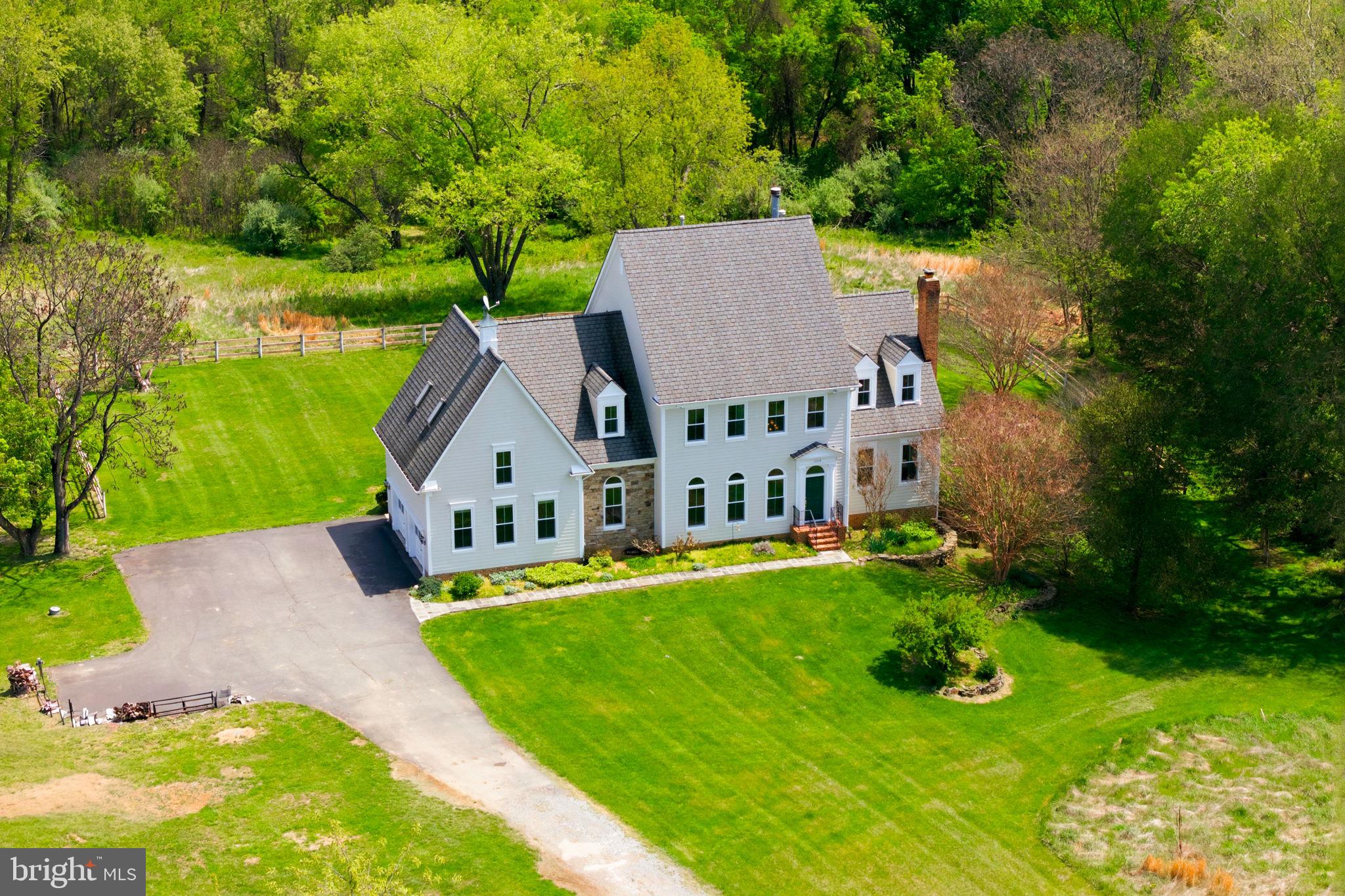 NO HOA,10 Acres with pool, $20,000 decorating credit for floors $carpet,. Property  private setting has run in shed and detached workshop both with electricity. Outside the historic village of Waterford Va. has rolling pasture and mature woodland, this exceptional residence offers a refined blend of timeless craftsmanship and elevated country living.  A resort-inspired pool with a striking dark-bottom finish—enhanced by extensive upgrades completed in 2025—is thoughtfully integrated into the natural landscape, while dual Trex decks overlook lush grounds, creating a seamless indoor-outdoor lifestyle ideal for sophisticated entertaining. Inside, rich American cherry floors, soaring ceilings, and artisan-crafted millwork define the home’s elegant character, enhanced by fresh paint throughout and all new windows and exterior doors. The sun-filled eat-in kitchen, appointed with new appliances, opens effortlessly to the deck, while the sunken family room—anchored by a dramatic stone fireplace and custom built-ins—features a wall of glass framing sweeping pastoral views. A gracious living room with fireplace and built-ins, along with a private study opening to its own deck, provide both intimate and formal living spaces. The upper level offers three luxurious ensuite bedrooms with walk-in closets, complemented by an expansive skylit bonus room. A walk-out lower level with laundry and abundant storage opens directly to the pool and gardens. Additional amenities include a run-in shed with electricity, a detached workshop with loft, an attached two-car garage, and a well-maintained HVAC system (approximately 7 years old)—completing this rare offering where privacy, beauty, and thoughtful design converge.