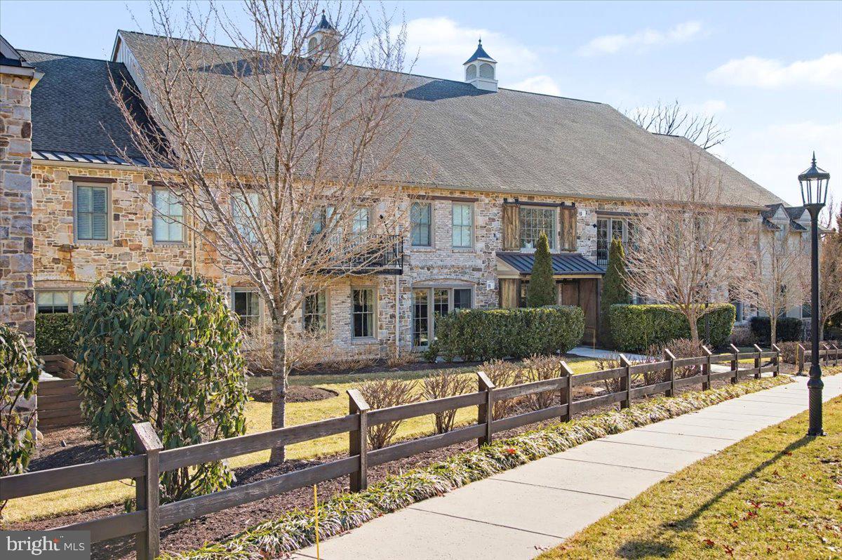 Welcome to Town’s Edge, an exceptional 55+ luxury condominium community created by Zaveta Custom Homes. True to its name, Town’s Edge is perfectly positioned at the edge of Doylestown Borough, offering residents a pleasant, gentle walk into the heart of town… close enough to enjoy everything Doylestown has to offer, yet set apart for privacy and tranquility.
This boutique community is comprised of just 10 residences, thoughtfully designed to blend timeless Bucks County character with refined modern living. The exterior draws inspiration from traditional Bucks County stone bank barns, while the interiors present a sophisticated, contemporary aesthetic defined by elegance, space, and light. Inside, you’ll find 9-foot ceilings, solid oak flooring, and an open-concept layout that creates an effortless flow for everyday living and entertaining.
The designer kitchen is outfitted with premium finishes and lighting, offering both beauty and function for the home chef. The generously sized primary suite, complete with a luxe bath, reflects the same high level of craftsmanship and attention to detail found throughout the residence. Every element - from the architectural design to the impeccable finishes - speaks to the quality and substance that define this remarkable property.
Step onto the private balcony and enjoy serene views of the community’s expansive rear grounds. The outdoor setting is a standout feature of Town’s Edge, featuring beautifully designed gardens, meandering walkways with stacked-stone walls, a historic stone springhouse, and a restored 18th-century structure now serving as an open-air pavilion. This inviting space includes gas grills, a fire pit, picnic tables, and ample seating… great for gathering with friends or simply enjoying the peaceful surroundings.
Each residence includes secure, heated and air-conditioned indoor garage parking along with a private 12’ x 16’ storage room, with elevators providing access to all floors. Residents also enjoy a well-appointed, private in-building fitness studio, adding everyday convenience and wellness to the lifestyle. Guest parking is plentiful, with 25 outdoor spaces serving the ten residences, and electronic security systems throughout the common areas provide added peace of mind.
Town’s Edge offers a lifestyle defined by quality, convenience, and thoughtful design — a place to truly enjoy the next chapter. This is an opportunity to focus on travel, family, hobbies, and the ease that comes with investing in a home where every detail has been carefully considered.