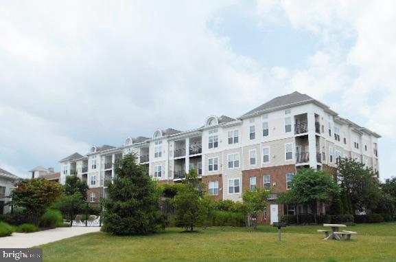 Nifty condo...nicely appointed with gleaming hardwoods, fireplace, laundry in unit, garage parking on your third story level.  Secured building ... secured garage parking ... You will love this convenient location.... Rt 66 and Dulles Airport both close by.        Community exercise room.   Professionally cleaned and ready for new tenant.    One or two year lease available.
