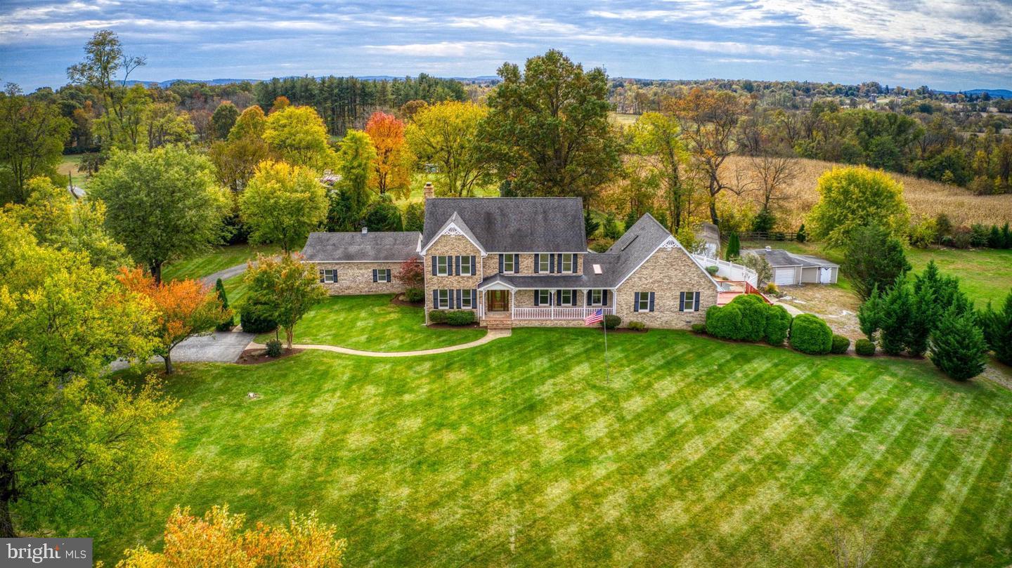 Experience the best of country living with close proximity to modern conveniences on this beautiful estate featuring a custom‑built brick home set on nearly 7 tranquil acres. Bring your horses—this property includes a fenced paddock, barn with electric and water, and multiple outbuildings, all just minutes from Frederick.

A large mechanical building at the front of the property is ideal for a home‑based business or workshop. The home offers an inviting open floor plan, charming front porch, 3‑car garage, gazebo, and an in‑ground fiberless pool with a brand‑new cover. Multiple outdoor living areas make this an entertainer’s dream.

Inside, the expansive kitchen with walk‑in pantry opens to a bright family room with a stone fireplace. Natural light fills the home through abundant windows. The main level features a dramatic two‑story bedroom or great room with a loft above, plus 5 full baths throughout. Upstairs offers three oversized bedrooms. The partially finished basement includes a full bath, walk‑up entrance, and wood stove.

Efficient zoned HVAC includes heat pump, propane, and EBB backup. Conveniently located 3 miles from the MARC Train and 10 miles from Harpers Ferry.