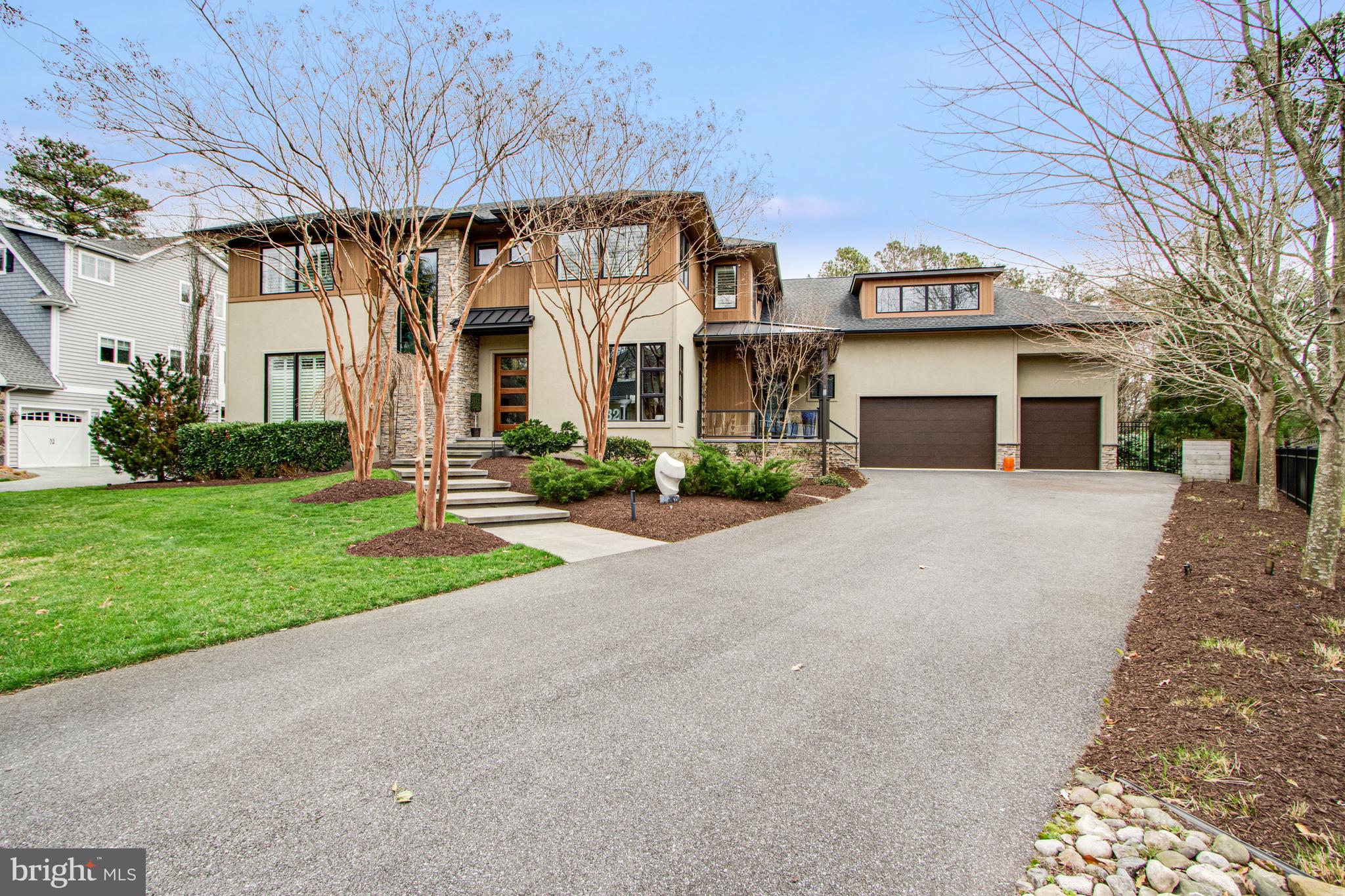 Welcome to 32 Eleanor Lee Ln. East, offering the luxury of privacy and convenience just steps from downtown Rehoboth Beach in the sought after Canal Corkran community. With over 7500 square feet of thoughtfully designed living space, there is plenty of room to relax and entertain in style. 7 bedrooms, all ensuite, including two extravagant co-primary bedrooms. Distinctive finishes abound including oak floors throughout the main floor, stone fireplaces and accent wall, and oversized sliding glass doors and custom windows bringing in light and providing views of the lush landscaping outside.  The gourmet kitchen has top of the line appliances like a 48 inch double oven Wolf range and Sub-Zero refrigerator, bar area with wine fridge, and beautiful custom granite slab countertops and backsplash. Dual gathering rooms, one with double height ceilings open to the upstairs, the second room with fireplace is open to the kitchen and dining area. An enclosed screened porch spans the rear of the house and is accessed by large glass sliders from the living spaced and first floor primary bedroom. This room showcases indoor-outdoor living, with views out back to the pool and canal, and a ductless mini-split system provides heat and A/C for year-round comfort and enjoyment. The formal dining room in the front of the house has views through large windows and a door to the covered side porch. Supplementing the kitchen is a large butler's pantry with second refrigerator, additional dishwasher, laundry, and a door to the backyard for easy access to a cold beverage from the pool area. The first-floor primary suite includes a spacious bathroom with oversized spa style shower and separate water closet, and door to a quiet nook of the rear porch. Upstairs there is a second equally impressive primary bedroom, and three additional bedrooms each with a private bath. One of these bedrooms is situated above the garage and has a heated bathroom floor and dedicated min-split system. The upstairs gathering room with stone fireplace has views to the canal and pool below. The large rear sundeck has glass railings for unimpeded views and a spiral staircase connecting to the pool area. Downstairs the finished basement has 9 foot-ceilings with two additional ensuite bedrooms, a media room, large game room, and an 8th bathroom, should you wish to use the game room as an exercise room. All this and a private boat dock with lift on the Lewes-Rehoboth Canal, private pool, Ipe wood outdoor shower, geothermal heating/air, and a three-car garage. Whether you keep this as your own private residence or take advantage of the lucrative weekly rental income, this bespoke home has everything one could wish for in a Rehoboth dream home.