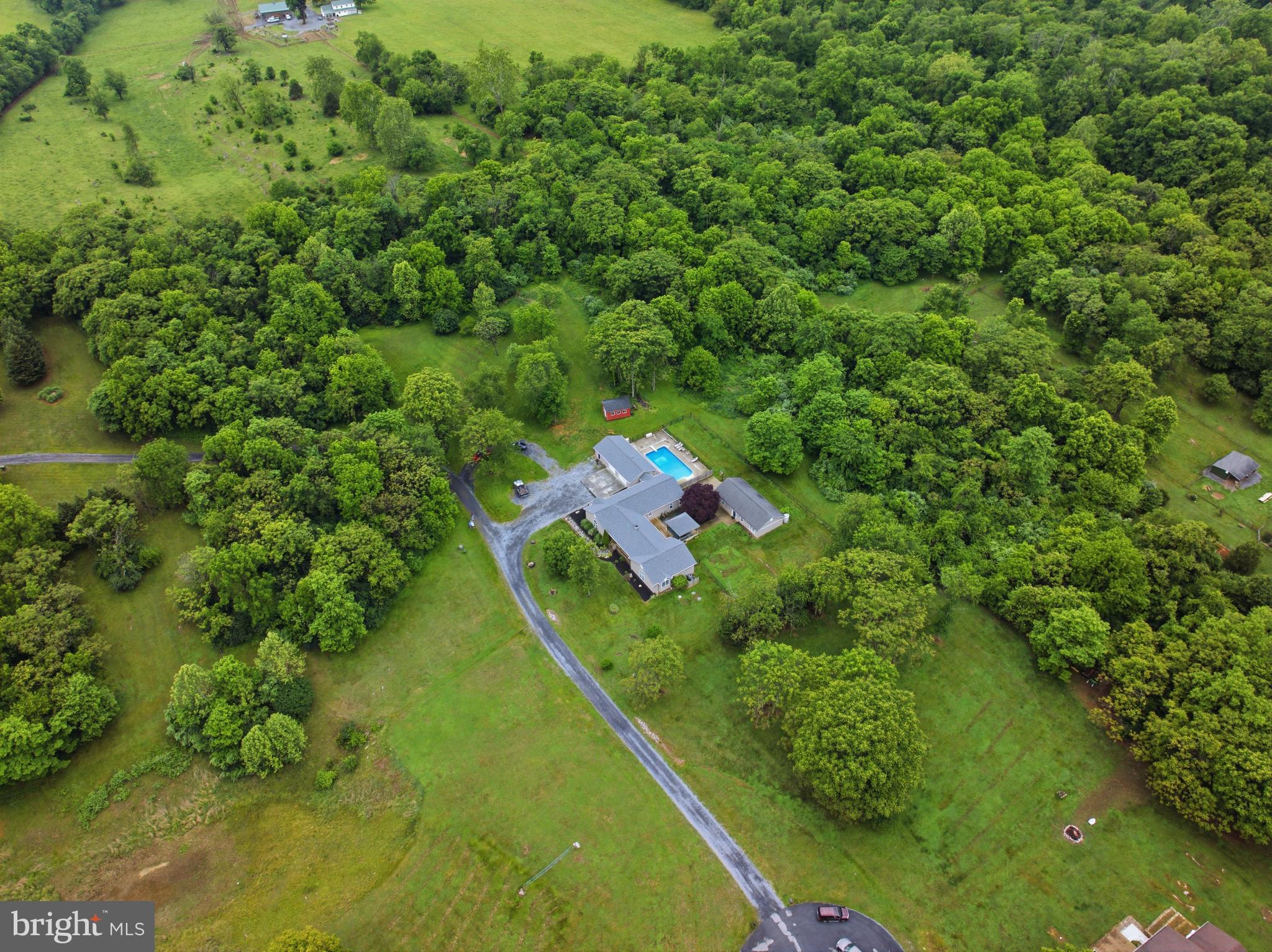 ***Open House -- Sunday, June 14th from 12-2 PM*** Rarely does a property offer the combination of acreage, versatility, and multigenerational living potential found at 125 Krynn Way. Whether you're looking for a private retreat, a homestead, or the perfect setup for multigenerational living, this one-of-a-kind property offers endless possibilities. Situated on 3 picturesque acres with peaceful farmland views and no HOA, the property features an approximately 3,600+ sq ft main residence with 3 bedrooms, 3 full bathrooms, and 1 half bath, as well as a fully separate 1,131 sq ft guest house offering 2 bedrooms and 1 full bathroom. Inside the main home, you'll find a beautifully remodeled kitchen complete with custom cabinetry, quartz countertops, stainless steel appliances, and a custom hood vent. Just beyond the kitchen is a spacious family room featuring soaring cathedral ceilings, a stunning stone fireplace, and an open layout designed for everyday living and entertaining alike. Two generously sized secondary bedrooms, each with their own private en-suite bathroom, are located just off the main living area. On the opposite side of the home, a private office, study, or reading nook leads to the expansive primary suite. The primary suite offers a massive en-suite bathroom with a true walk-in tiled shower and a custom walk-in closet. This wing of the home also includes a powder room and a laundry room with built-in storage. Toward the rear of the home, a large recreation room provides endless flexibility and could easily serve as a second family room, game room, media room, or hobby space. This area flows into a mudroom with direct access to the oversized approximately 1,200 sq ft garage, complete with two garage bays, workshop space, and abundant storage. The home has been thoughtfully updated with dual-zone electric HVAC with propane backup, two propane-fueled tankless water heaters (approximately 2 years old), a newer architectural shingle roof (approximately 4 years old), and a propane-fueled whole-house generator (approximately 2 years old) for added peace of mind. Step outside and experience your own private oasis. The outdoor living space features a 20x40 inground pool with a newer liner (approximately 4 years old), a gazebo, custom firepit patio, and plenty of room to enjoy the surrounding countryside. Deer frequently roam the property, adding to the tranquil atmosphere and natural beauty. Properties like this rarely come to market. Offering a unique blend of privacy, versatility, and room to grow, 125 Krynn Way is truly a special place to call home.
