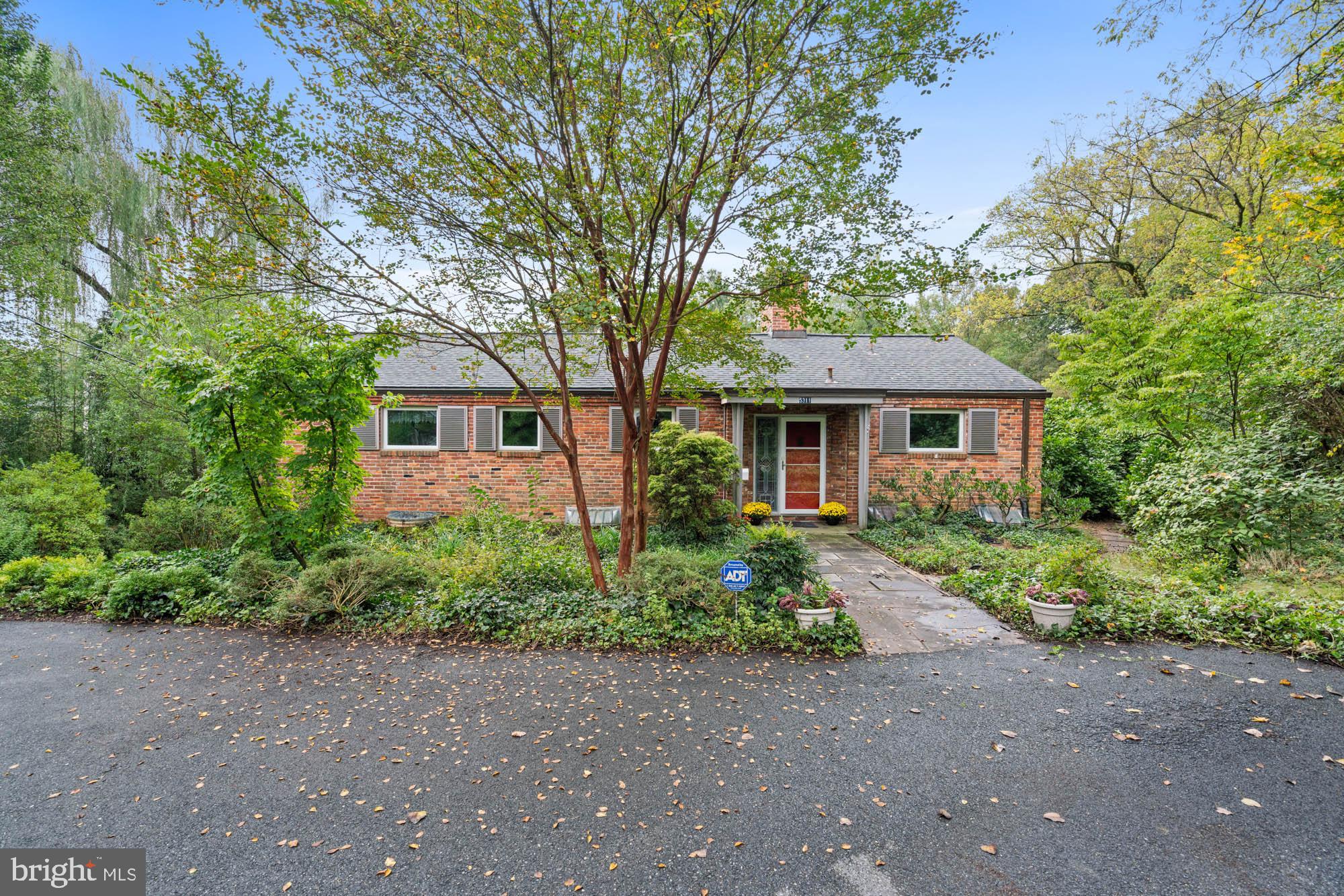 Serenely nestled on nearly an acre in the heart of the Green Acres neighborhood of Bethesda, this distinctive mid-century modern home delivers the most unique suburban setting with great convenience to Washington, DC, downtown Bethesda, and Northern Virginia. 

There is a wonderful sense of privacy in nature with expansive mature tree top views and rolling, verdant grounds. Stone walkways and a back terrace spanning the length of the home take advantage of the natural views - perfect for outdoor gatherings and relaxation. This tranquil brick and slate home encompasses approximately 2,900 +/- square feet on two levels of living and enjoys four bedrooms and three full bathrooms. Featuring one-of-a-kind details throughout, including stone and exposed brick walls, gleaming hardwood and hand-laid  stone floors, two fireplaces, and light-filled rooms with oversized windows. Additional offerings include an attached workshop, potting greenhouse, a storage shed, and a spacious driveway for ample off-street parking.  

The nearly acre lot is resplendent with mature trees, flowering bushes, and a variety of plantings that bloom throughout the year. The rolling topography undulates from the stone terrace as it cascades down towards the creek bed. Backing to protected wooded parkland, the lot offers ample space for gardening, romping with dogs or children, and a quiet, verdant respite from the busy life that surrounds the property. Subdivided decades ago, this parcel was designed to provide a true oasis in the middle of a close-knit typical suburban development. 

5311 Allandale Road benefits from urban-suburban living at its finest. The Little Falls Swimming Club, the Capital Crescent Trail and neighborhood parks close-by, while being convenient to the Friendship Heights Metro, many shops, restaurants, bus stops, major transportation routes, with easy access to DC, World Bank, IMF, Embassy Row, NIH, Walter Reed and other major employment centers. A wonderful opportunity to make this peaceful retreat your own! Westbrook, Westland, and B-CC schools serve the neighborhood.
