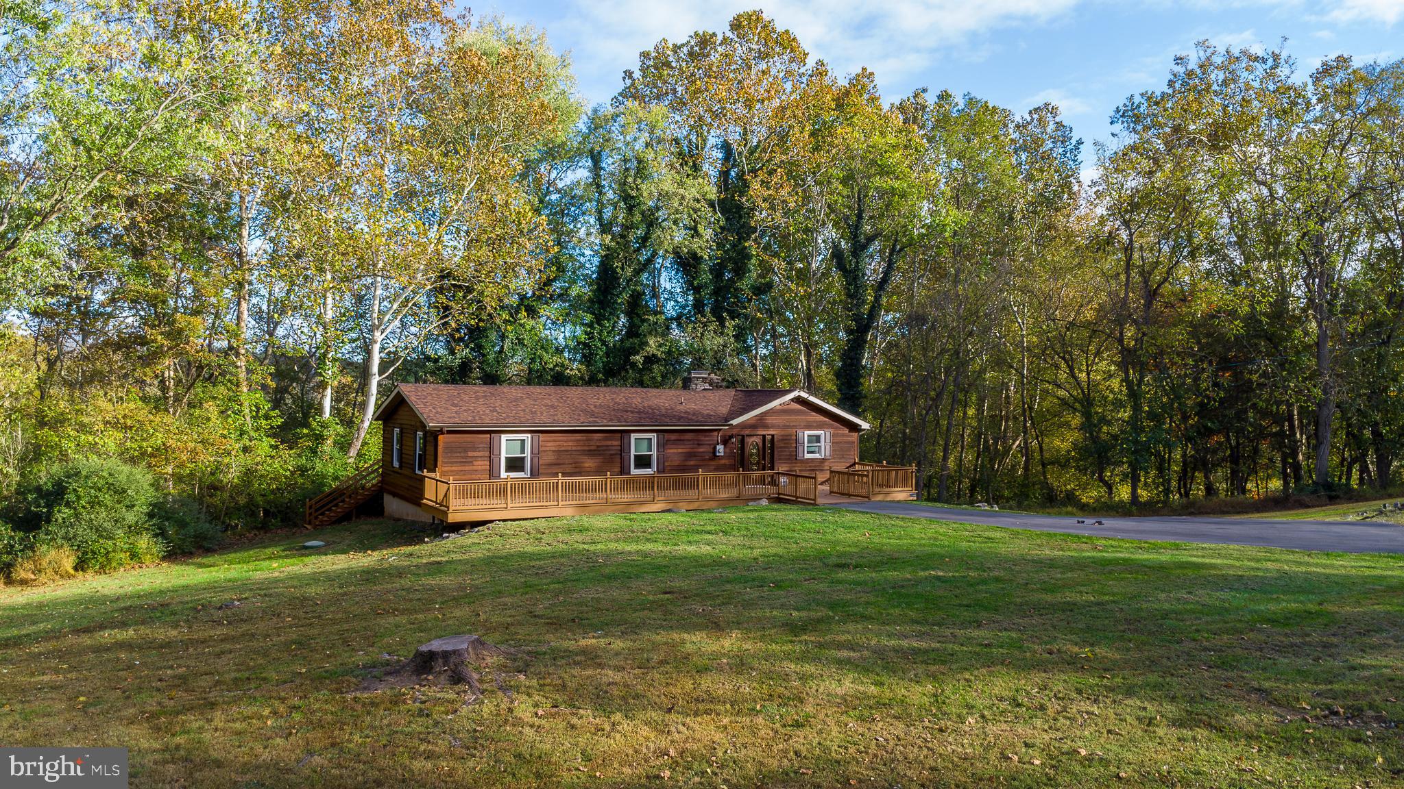 Well maintained 2080sf ranch style home in a cozy spacious setting of  3 acres  just minutes from downtown Shepherdstown.   Very large decks on both the front and rear of the home.  The back deck has a view of a neighboring lake in the fall and winter months, and can be accessed from the living area as well as the primary bedroom.   Stunning hardwood floors throughout.  Stone two sided fireplace as a centerpiece between the living area and kitchen/dining area.  Granite counter tops and plenty of cabinets.  Large out building with garage door and side door.  Come check out this getaway and maybe be lucky enough to call it HOME!!