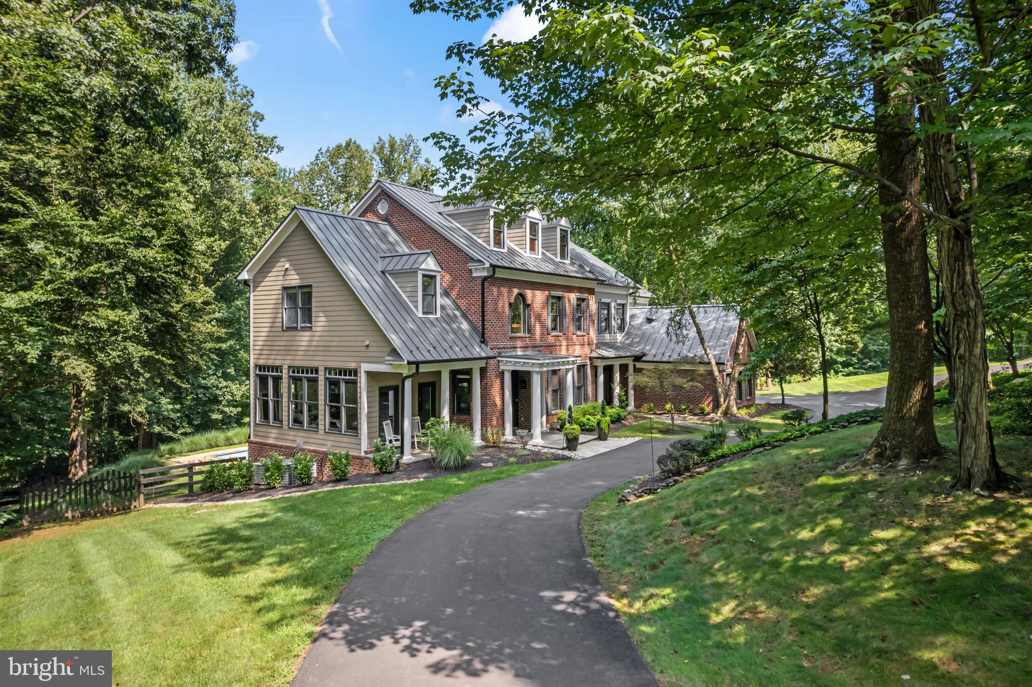 Cradled in the heart of prestigious Beacon Hill, this stunning 2024 remodeled estate epitomizes luxury living on a serene 3-acre partially wooded homesite. This custom masterpiece, featuring 5 bedrooms, five full and two half bathrooms, blends sophisticated craftsmanship and design with modern comforts for an unparalleled living experience.
Step inside to discover new Collington collection Champagne Oak hardwood floors that move you from an elegant foyer to the heart of the home. The open, light-filled floor plan is designed for peaceful living or entertaining, featuring soaring ceilings, custom built-in cabinetry in the living room, and cozy fireplaces that add warmth and charm. Expansive windows and doors frame breathtaking views of the surrounding wooded paradise, seamlessly blending indoor and outdoor living. The entire interior and exterior have been freshly painted with Farrow and Ball colors, enhancing the refined ambiance.
The dream kitchen showcases brand-new Jenn Air appliances, custom Omega quartersawn oak cabinetry, and sleek stone countertops. A spacious center island serves as the perfect hub for culinary creations, while the open connection to the family room—complete with a vaulted 12 ft ceiling, fireplace, and abundant natural light—creates a warm, welcoming space for gatherings. Adjacent, a large mudroom with custom built in lockers, offers practical storage.
Upstairs, accessed via dual staircases, the luxurious owner’s suite awaits, walk-in closets and bathroom with elegant quartz countertops and modern finishes. All five spacious bedrooms on this level offer private bathrooms, new hardwood, and generous closet space. A well-appointed upstairs laundry room with ample workspace adds convenience to daily living.
Outside, the newly installed metal roof, gutters, downspouts, and gutter guards ensure durability and low maintenance. A horseshoe driveway welcomes you home, while a rebuilt front porch, expansive wraparound back deck, private pool with new coping stones, and a backyard paver patio create an oasis for relaxation and entertainment amidst nature’s tranquility. Enhanced landscaping, drainage, and foliage elevate the outdoor experience, complemented by a new well pump for reliable water supply. New lighting fixtures throughout and remodeled downstairs half bathrooms add modern elegance to every corner of the home.
This brick estate home with HardiePlank accents, exudes custom-home sophistication. Perfectly situated near Loudoun’s finest restaurants, shopping, vineyards, and breweries, this home offers endless opportunities for leisure and recreation. Experience the pinnacle of Loudoun living at Black Gold Place, where luxury, privacy, and natural beauty converge to create a truly exceptional residence.