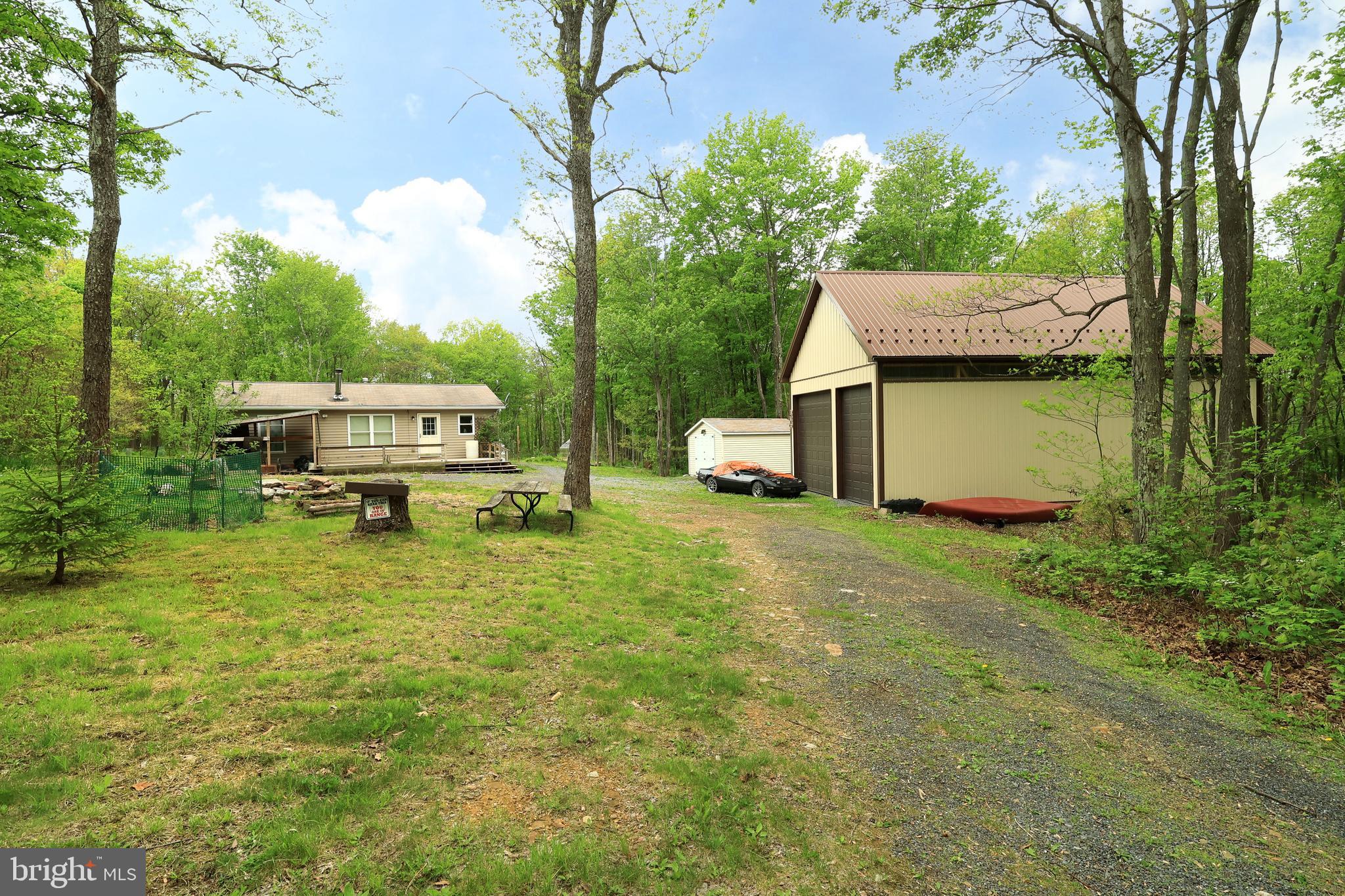 Nestled on 3 private acres adjoining Sproul State Forest, this 3-bedroom, 1-bath property can be used as a full-time residence or a peaceful getaway surrounded by nature and abundant wildlife. The setting offers privacy, recreation, and direct access to endless outdoor opportunities. Inside, the home features an open-concept layout connecting the living room and kitchen, creating a comfortable and functional space for everyday living or weekend escapes. A wood-burning stove adds warmth and character, making it a cozy gathering space after a day outdoors. Step out onto the spacious back deck overlooking the property’s natural surroundings, complete with a pool for summer enjoyment. The grounds are enhanced with mature apple trees, flowering plantings, and a 6’ x 16’ greenhouse—ideal for gardening, hobbies, or simply enjoying the land. For storage, workspace, or recreational equipment, the property includes a 24' x 44' garage with a full second level, along with an additional storage shed, offering exceptional flexibility and room for all your needs. Outdoor enthusiasts will appreciate direct access to Sproul State Forest, with nearby access to Bloody Skillet and the Snow Shoe Rails to Trails system. Hunting, riding, hiking, and exploring are all right outside your door. A rare opportunity to own a private, nature-rich property with space, privacy, and year-round usability.