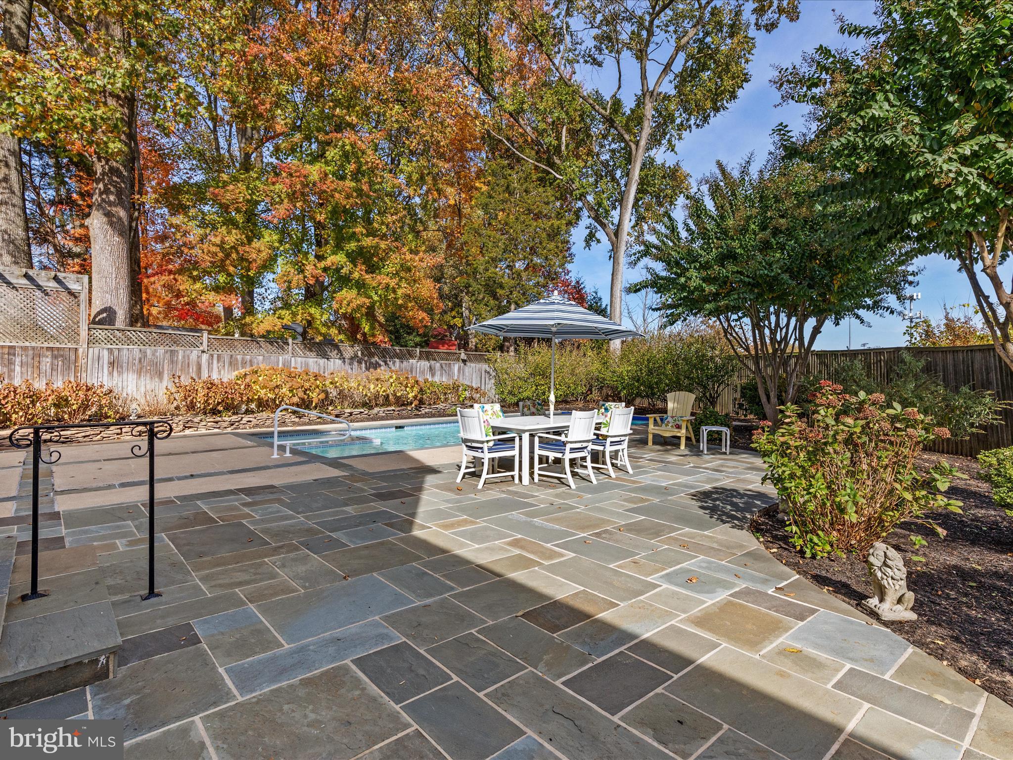 Are you ready to be wowed? Welcome to 933 Ridge Dr, McLean, Virginia, where the saying “Don’t judge a book by its cover” truly comes to life. The owners have spared no expense in recent updates and in the overall care of this stunning four-level home.

As you step inside, you’ll be greeted by gleaming hardwood floors, an open and airy floor plan, and an abundance of natural light. The expansive living room features a cozy fireplace and flows seamlessly into a lovely formal dining room with oversized windows that invite the outdoors in.

On the main floor, you’ll find a spacious office with built-ins, perfect for those working from home. The eat-in chef’s kitchen is a culinary delight, boasting top-of-the-line appliances (consisting of Subzero and Wolf), granite countertops, and an overlook into the family room—ideal for whipping up fresh cookies or game day snacks, making it an entertainer’s dream.

The family room, complete with a bar / wet bar and fireplace, creates a perfect setting for family movie nights or recreation. Convenience is key here, with a large storage closet and new updates in the half bathroom.

But there’s more! The fourth lower level offers a legal bedroom, a full bathroom, and a spacious seating area, providing endless possibilities for guests or relaxation. As you ascend to the top floor, you’ll discover the master suite, a true sanctuary featuring an eclectic charm, an accent wall, new recessed lighting, and a huge walk-in closet. The luxurious master bathroom, adorned with porcelain tiles and new fixtures, exudes Hollywood glamour.

With fresh paint throughout, updated fixtures, and recessed lighting, every detail has been considered.

Your backyard oasis is nothing short of dreamy, with an in-ground pool and in-ground hot tub that has been the highlight of countless memories and fun-filled days. Surrounded by meticulously landscaped gardens, lush greenery, and vibrant blooms, this outdoor retreat offers a serene escape. The thoughtfully designed pavers patio provides ample space for lounging and entertaining, creating a picturesque setting for gatherings and relaxation.

This home also features a three-car garage, two driveways, and a lovely greenery escape on the side of the home perfect for additional seating and late night hot chocolate around a fire pit.  Conveniently located near commuter routes, fine dining, shopping, and so much more, this home truly has it all. Don't miss the chance to experience this extraordinary property!