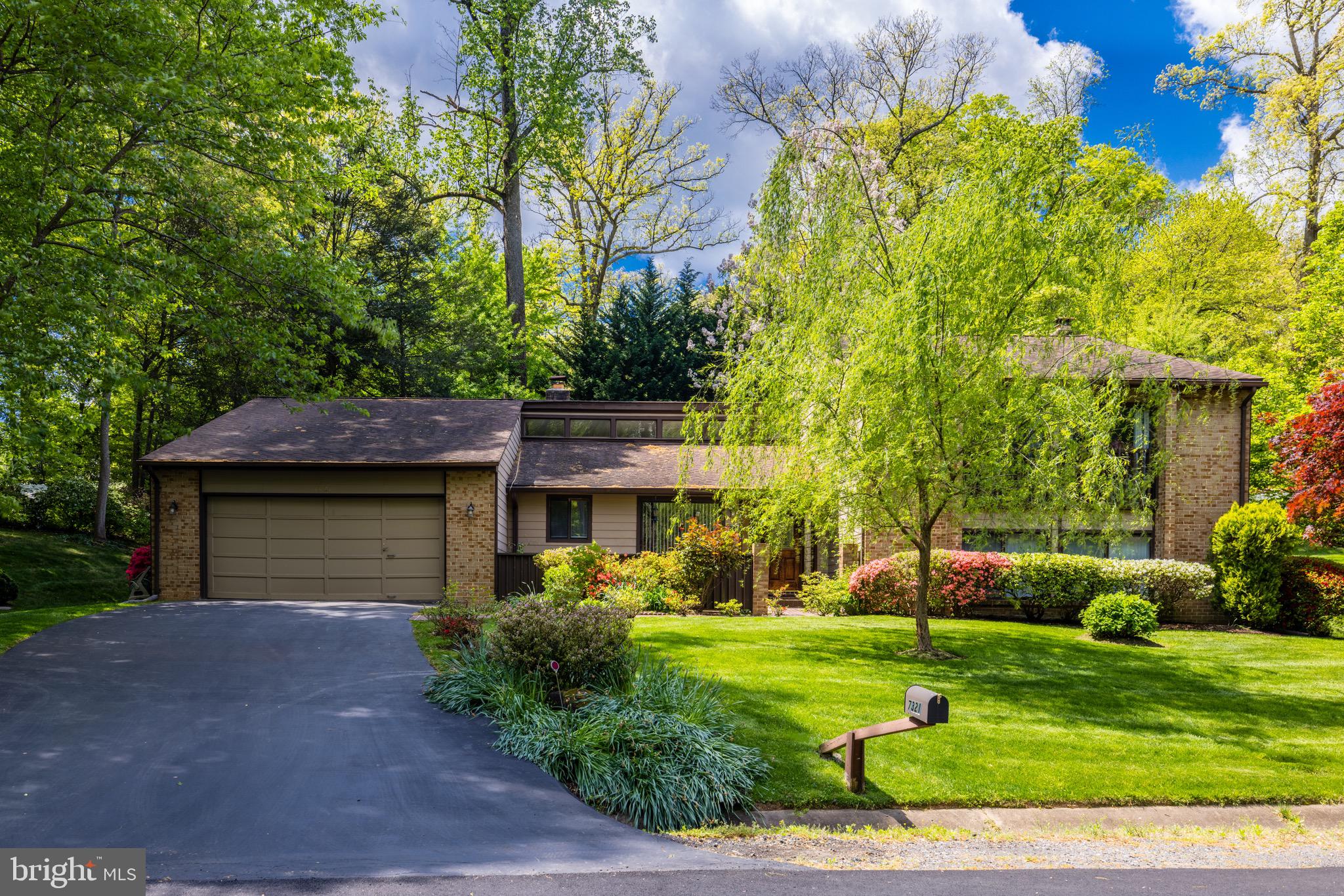 Welcome to 7321 Hooking Road, a meticulously maintained contemporary home nestled in one of McLean's most desirable areas. This 5-bedroom, 3-bathroom property offers over 4,250 square feet of light-filled living space on a beautifully landscaped half-acre lot.

The mirrored foyer leads to a spacious living room with a floor-to-ceiling brick fireplace and a wall of windows that bathe the room in natural light, offering great views of the private backyard. The formal dining room is perfect for hosting dinner parties and special family gatherings. Both the living room and dining room feature vaulted ceilings.

The gourmet kitchen is a chef’s dream, boasting natural wood cabinets, granite countertops, and a center island with a breakfast bar. The breakfast nook has lovely views and sliding glass doors leading to the front courtyard. There's also a sunroom with a wall of windows and sliding glass doors to the backyard. The large family room includes a raised hearth brick fireplace, a wet bar, and sliding glass doors to the back patio. Additionally, the main level features two bedrooms, a full bath, and a laundry room.

Hardwood floors extend throughout the upper level. The master suite is a true retreat with a dressing room that could serve as an office nook and an en suite bathroom. There are two additional bedrooms and a full hall bath.

The finished basement provides extra living space with a large recreation room, two storage closets, and a wine room with a bar. The beautiful and private backyard is an entertainer's paradise with mature trees and plenty of space.