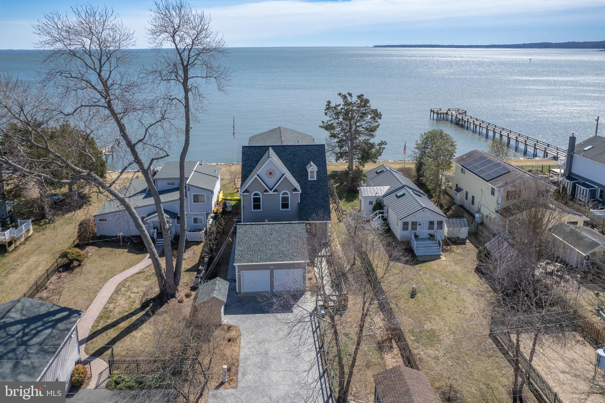 ** If you want the best views in town, this is the home for you, with Southeastern views that just get better the further up you go!! This three level, over 4,100 square foot home has so much to offer it is hard to know where to begin.  Located in the Owings Beach Community of Deale, MD, this home offers 4 bedrooms, 2 and a half baths, three full floors of living as well as a two-car detached garage with storage above.  When you walk into the main floor of this home you are immediately struck by the beautiful views of the Chesapeake Bay, and if you can pull yourselves away from the views, you will see a fantastic kitchen with updated appliances and solid surface counter tops, two sinks each with their own disposals, a built in wine fridge, as well as hardwood floors that run throughout the entire home.   The living room features a propane fireplace, brand new sliding doors to the outdoor paver patio area. The dining area also walks out onto a lovely screened in porch.  Additionally on the main level you will find a large pantry/utility room, a half bath, the laundry room as well as additional storage.  Moving up to the 2nd level you have 4 bedrooms and 2 baths.  The primary bedroom offers a walk out deck for those morning sunrises, as well as a full ensuite to include a new double vanity, a soaking tub and large walk-in shower.  There is a hallway bath that serves the 3 other bedrooms on this floor that has been recently updated with new lighting, counter-tops and vanity.  The third level is something to see :) it is a large open space that could be used for a media room, a bunk room, an exercise room, the possibilities are endless in this space. There is also a very large storage area on the third floor that is more than anyone could ever need for storage!  The entire home has just been professionally painted to include walls, ceilings and trim.  A new roof was installed this year, and the HVAC was replaced in 2021.   This home is move in ready! ***If you work in DC and would like to take the MTA Bus - bus 820 leaves from the Equestrian Center in Upper Marlboro and makes stops at 7th & D as well as other stops in DC. The Equestrian Center is 24 minutes from this home. ***