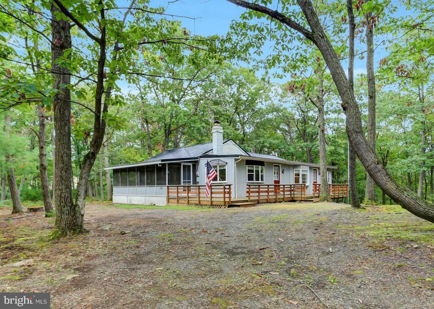 Welcome to peaceful mountain living on 3.5 wooded acres.  HOME  HAS  HOLDING  TANKS  FOR  SEPTIC,  CASH  OR  CONVENTIONAL  BUYERS.    This well-maintained home features a screened-in front porch, new wooden deck, updated kitchen and baths, plenty of windows, main-level laundry, and a cozy fireplace. Heating and cooling include a pellet stove, electric baseboard heat, and HVAC with central air. The walk-out basement offers storage and workshop space.  Hunters paradise, state games lands are close by a short distance away from the property.
The property offers plenty of room to park an RV, boat, and other recreational vehicles. Located just minutes from Cowans Gap State Park, enjoy a 42-acre lake, swimming, boating, fishing, biking, and scenic hiking trails. Conveniently situated about 15 minutes to McConnellsburg and Mercersburg, and 30 minutes to Chambersburg, for shopping, dining and other entertainment. Corner pins are marked orange ribbon.
BEST ROUTE TO THE PROPERTY - Rt. 30 onto Rt. 75 N at Fort Loudon to left onto Richmond Rd. towards Cowans Gap State Park. Left onto Lakeview Dr. then Right onto Myers Dr. property on the Left. BEST NOT TO FOLLOW GPS.