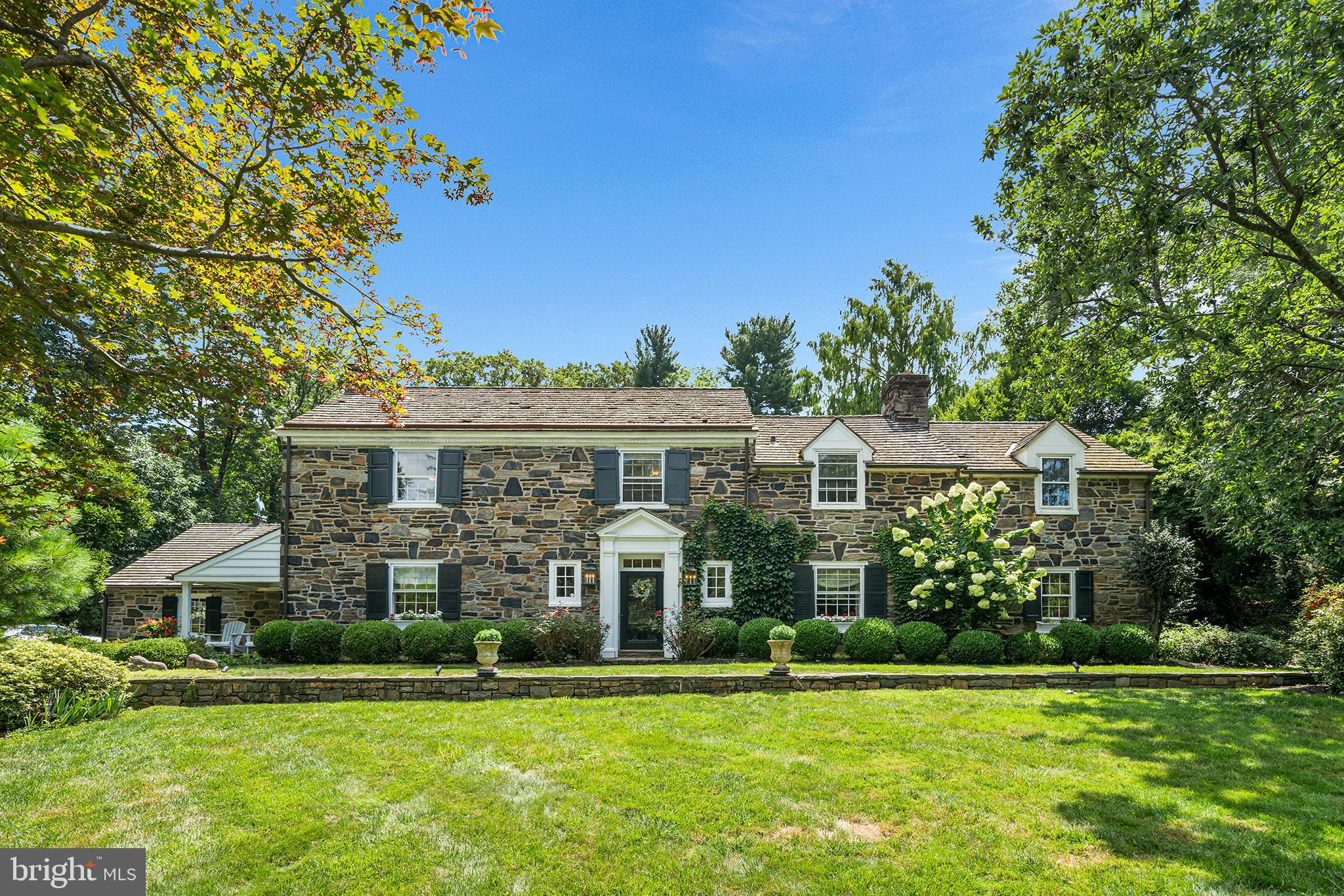 Welcome to this charming, classic stone home nestled in the serene enclave of St. Davids, where timeless architecture meets lush, storybook landscaping. With four bedrooms and two-and-a-half bathrooms, this residence is a rare blend of character, comfort, and thoughtful design. A winding stone pathway invites you in, surrounded by mature landscaping that rivals the gardens at Chanticleer—ivy-covered walls, colorful hydrangeas, and curated gardens set a picturesque tone from the moment you arrive.

Step inside to find a warm and inviting living room to the right, featuring rich hardwood floors, recessed lighting, a bay window, and a wood-burning fireplace with classic brick surround and a white mantle. Just beyond lies a cozy home office, complete with wood-paneled walls, built-ins, and stone flooring, plus access to a tranquil side porch.

The tiled eat-in kitchen is as stylish as it is functional, boasting a center Carrara marble island, counter seating, Wolf/Sub Zero stainless steel appliances, Stoltzfus cabinetry, and striking Julie Neill Alberto open cage lantern pendants. A charming circular breakfast table sits just off the kitchen, creating the perfect spot for casual meals. The kitchen flows effortlessly into a light-filled family room with cathedral wood ceilings, crown molding, and large windows overlooking the lush backyard. Throughout the home, all lighting fixtures and sconces are antique, adding to its refined character.

The formal dining room exudes elegance with wood floors, crown molding, a sparkling chandelier, and a bay window. On this floor, you’ll also find a beautifully appointed powder room, complete with a Celestine Basin from the London Basin Company and Sibylla wallpaper imported from London, as well as a mudroom designed for dirty boots and dog gear, accented by Clarke & Clarke wallpaper and anchored by a large armoire in place of cubbies. The main floor laundry room also features the same designer wallpaper, bringing a sense of cohesion and charm to these practical spaces.

Step out back to a stunning stone patio with a charming half-wall, surrounded by flourishing gardens—a true outdoor retreat for relaxing or entertaining. The backyard is a private haven, fully enclosed by a wooden fence, and features a 42-inch Pompeii-style brick pizza oven, a fountained lily pond with goldfish and frogs, and lush landscaping that creates a sense of tranquility and escape.

Upstairs, to the left, you'll find a Jack-and-Jill bedroom suite. The first bedroom features soaring ceilings and a ceiling fan, while the adjoining second bedroom offers an entire wall of built-ins with a convenient desk at the center—perfect for work or study. Down the hall is a third bedroom, currently set up as a home office with a daybed, highlighted by wall paneling and a ceiling fan. At the end of the hall, the spacious primary suite impresses with high ceilings, an exposed stone accent wall, and French doors that open to a private deck overlooking the backyard, complete with a circular staircase for easy outdoor access. The en-suite bathroom includes marble countertops, a soaking tub, an oversized glass-enclosed stall shower, and a towel heater, while the nearby walk-in closet offers generous built-ins for organized storage.

Other highlights include a cedar roof, indoor access to the two-car garage, and an unfinished basement accessed via the kitchen—perfect for storage or future expansion.

Located just a short walk to downtown Wayne, Fenimore Park (ideal for fishing and winter ice skating), and the scenic grounds of Eastern University with its peaceful walking trails and ponds, this home offers the tranquility of a luxury English village with the convenience of award-winning public schools and easy access to amenities. An absolute gem in one of the Main Line’s most coveted neighborhoods.
