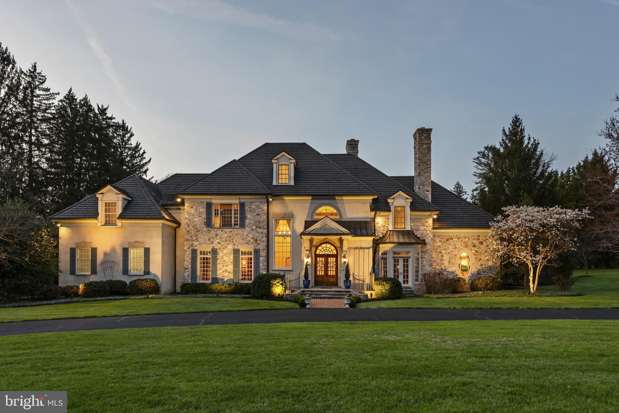 A   SURPRISE awaits you in Ruxton. Besides a home that showcases a stunning French Traditional architectural style, you will find a home that features a harmonious  mix of stone and stucco that exudes timeless appeal and highlights, in it's design, the history of the location.   The SURPRISE is  you will find on the property the remnants of the original Boordy Vineyard dating from  1943. The original winery building still exists with wine racks and a foundation stone documenting the Wagner family as the vintners, to establishing the brand "Boordy Winery".  Mimicking  wine country charm, this house is all about RUSTIC ELEGANCE  and WARMTH with details like exposed wooden beams,  interesting ceiling treatments, wood and stone heated floors, intricate moldings, custom millwork, wrought iron railings, stained glass, arches, and an abundance of fireplaces (5). The home boasts thoughful features that enhance everyday living like the large  27x23 gourmet eat-in kitchen, ageless in it's appeal yet highly functional. You will find high-end appliances seamlessly integrated into the design, like a 6 burner professional range and hood, equally sized side by side refrigerater and freezer, wine frig, pantry and coffee bar station. The granite breakfast bar/island is stratigically laid out to eliminate unnecessary steps when preparing a meal.  Adjacent to the kitchen is a 21x19 great room with a soaring 13 foot beamed ceiling, heated floor and gas fireplace.  This blend of old world charm makes the great room and kitchen a true gathering place.  The 1st floor primary bedroom suite unfolds as a private retreat, blending elegance and comfort.  The room is anchored by a curved back-lit ceiling that casts a luminous wash, ideal for evenings when a calm cocooning athmosphere is desired.  Together with the sitting room and spa bath, this personal haven is designed for both  rest and renewal. Rounding out the 1st floor is a gracious foyer, the formal dining room and living room, the library, 2 half baths and a very practical mud room.  Ascending to the second floor you will find 4 bedrooms, all with ensuite bathrooms and walk-in closets.  Anchoring this floor is a media room to enjoy any entertainment genre while popping corn or roasting hot dogs in the fireplace.  The 3rd floor affords 750 sq ft of finished open space with a full bath.  The lower level is unfinished but with a heated floor and fireplace. Outside, the 1.82 acre lot is a private oasis backing to trees and nestled in a peaceful cul-de-sac. The beautifully landscaped yard features a circular driveway, underground lawn sprinklers and a flagstone patio. The winery building offers 6 of the 9 car garage spaces plus around 2000 square feet of heated and cooled flex space. This home is ready to welcome you.