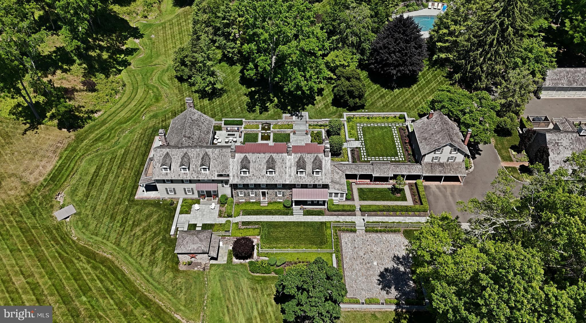 For only the second time in over a century, the pre-eminent legacy Bucks County masterpiece property known as Jericho Farm is available for purchase. Steeped in rich history, with original structures dating back to 1765, this presents a once in a lifetime opportunity to acquire a true family compound in an enchanting location. Boasting 147 spectacular acres, there are 3 dwelling units as well as other guest quarters interspersed among a total of 11 structures. Upon purchasing the property in 2012, after 90+ years of continuous ownership by the Bristol family, the current owners embarked on a four year long meticulous rebuilding of every structure from top to bottom, as well as tripling the size of the main house. The remarkable transformation can only be described as stunning. The splendid team of architect/ designer Paul Kiss of OSK Designs & master builder Tim Sager of Ferman Lex Custom Homes combined to re-invent and re-build the property for 21st century living and beyond. No stone was left unturned – literally – as every square inch of stonework inside and out was repointed. The grounds are equally as magnificent, with rare specimen trees, lush manicured landscaping, multiple patios, water and formal gardens, and a long tree lined driveway once beyond the gated entrance. Featuring 70% woodlands and 30% manicured grounds, ½ mile of road frontage, there are walking trails through the woodlands, leading to the very top of Jericho Mountain in the heart of Upper Makefield. The main house rebuild and expansion, using reclaimed wood and original beams as beautiful elements, now totals approximately 7,800 square feet, and boasts 4 spacious bedrooms, w/4 full and 2 half baths. A well appointed gourmet kitchen would be any chef’s dream, offering an 18’ island and top of the line appliances and all custom cabinetry. The kitchen overlooks a two story family room with hand hewn beams and floor to ceiling fireplace. A fully glass enclosed conservatory imported from England, office, original keeping room with walk in fireplace, living room, sunroom complete the main floor.  The second floor houses the primary suite, luxurious primary bath & large balcony offering endless western sunset views. Two bright and airy bedrooms with ensuite baths compete the second floor. The third floor is a large bedroom suite and full bath. There are two laundry areas in the main house. The second largest dwelling unit is the two story Cottage. It features 3 bedrooms, 2 full baths, gourmet kitchen, 2 car garage, charming front porch and back patio. Additional structures are a pool house with outdoor covered patio & fireplace, two level office with gym space in lower level, enchanting 8 stall horse barn featuring original wood stalls with second floor game room. The Guest House includes a complete one bedroom apartment. The Carriage House, with a 2 car garage, features a one bedroom suite, 2 bathrooms and large sitting area. The Shed is a large L shaped garage for either a car collection or to store farm equipment. The Greenhouse is attached to the former kennel, which is now a game room/man cave. There is an original spring house, additional 3 bay garage for more equipment, and last but not least a chicken coop for fresh eggs daily. All buildings are neutrally appointed and in mint move-in condition. The almost 19 acre building envelope on this conserved property is spacious enough should there be any additional structures you may want to add. Be prepared to be captivated by this iconic property and everything that it represents - privacy, tranquility, craftmanship, and a time-honored mission to preserve the historic qualities that make Bucks County a special place. Located in Upper Makefield just minutes to New Hope, Newtown, Doylestown and to New Jersey Bridges. 50 minutes to Philadelphia, 75 minutes to shore points, and 90 minutes to Manhattan. This incomparable, distinguished property is without peer. Now is the opportunity to make it your own.