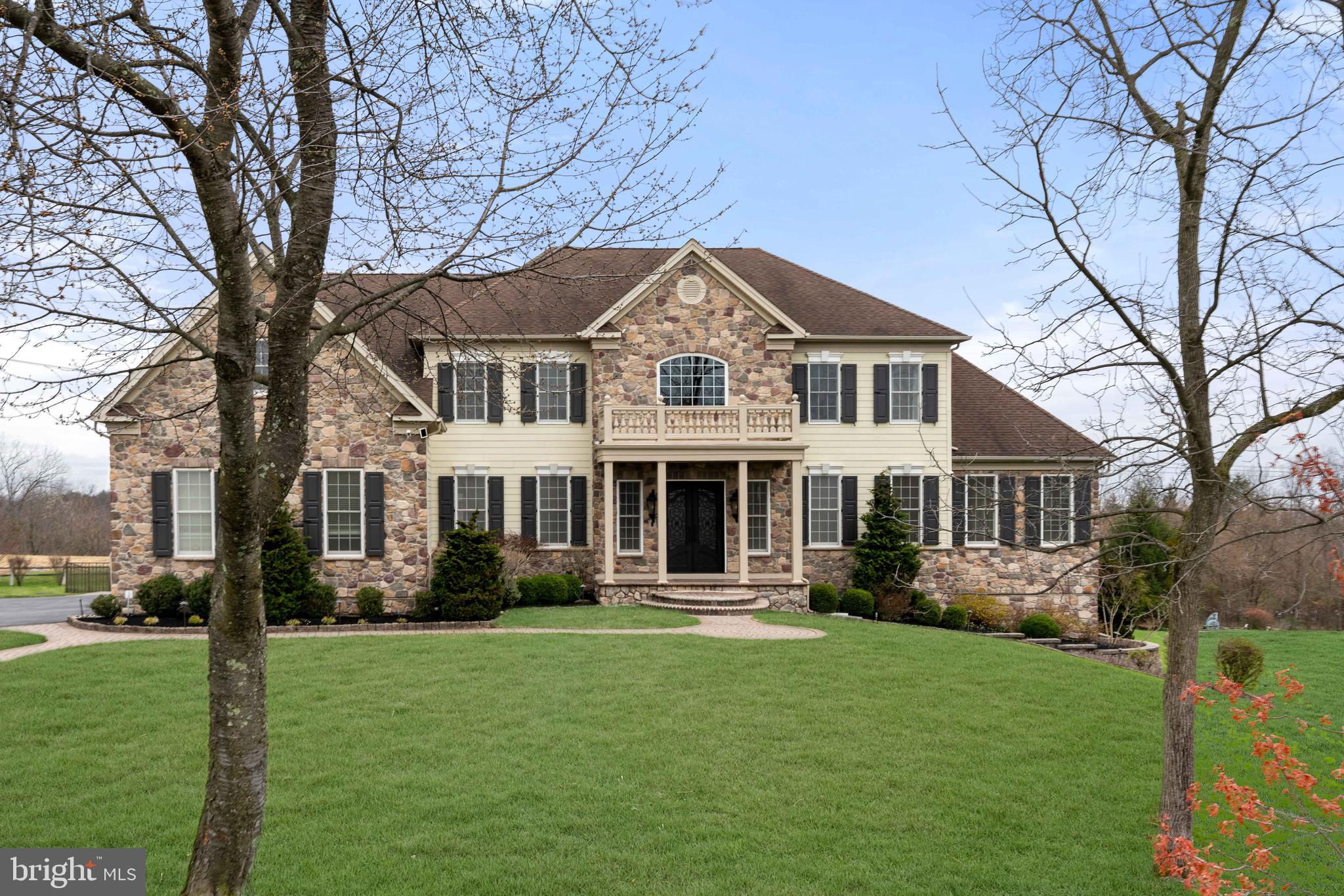 Indulge in the epitome of opulence within this sprawling 6,000 sq. ft. residence in the esteemed Estates at Hilltown. Majestically situated against preserved land, this four-bedroom haven boasts five full bathrooms, two half baths and 3 car garage, greeting you with a captivating butterfly staircase in the foyer. The main level unfolds with a formal living and dining room adorned in hardwood floors and custom crown molding. A vaulted-ceiling conservatory beckons, featuring a wet bar with granite countertops and a seamless transition to a vast composite deck overlooking the expansive backyard. The chef's kitchen is a culinary masterpiece with double wall ovens, a pantry, and granite countertops framing awe-inspiring views. Experience sheer magnificence in the great room- a masterpiece of design. Towering two-story ceilings, rich hardwood floors, coffered ceiling, a gas fireplace with floor to ceiling stone, and a second staircase redefine luxury living.  An office, 2 powder rooms, and mudroom complete this floor. Ascend to the second level, where the primary suite awaits with vaulted ceilings, a sitting room, and a lavish en suite featuring heated floors, Jacuzzi tubs, and an oversized walk-in shower. Two bedrooms boast Juliet balconies with attached bathrooms, and a fourth bedroom offers its own en suite. Technological marvels abound, from the ozinator pool and new Bose system to the updated lifestyle system and outdoor speakers with lifetime warranty. The entire house is fortified with Ring flood and spot cameras, ensuring security. The residence, adorned with Timberlane shutters, presents a full irrigation system and a basement ripe for customization. This home is a sanctuary for those seeking a luxurious retreat with unparalleled amenities.