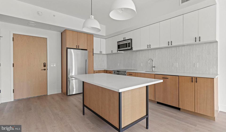 Step into your brand-new home at Ravel and Royale, where 2024 construction means everything is pristine and untouched, built specifically for the modern lifestyle you deserve. This expansive three-bedroom, two-and-a-half-bathroom penthouse residence spans 1988 square feet of thoughtfully designed living space, available now for immediate occupancy.

Your mornings begin in the stunning open-concept kitchen, where upgraded countertops create the perfect workspace for your coffee ritual. Stainless steel appliances gleam under natural light, including a full suite with dishwasher, disposal, self-cleaning oven, range hood, and built-in ice maker for effortless entertaining. The microwave and refrigerator complete this culinary haven, while the open floor plan seamlessly connects your cooking space to the living areas, making every meal feel like a celebration.

Wood floors flow throughout the residence, creating warmth and continuity from room to room. Walk-in closets provide generous storage, while ceiling fans ensure year-round comfort. The convenient in-unit washer and dryer mean laundry day never disrupts your schedule, and the entry-level bedroom offers flexibility for guests or a home office.

Beyond your front door, Ravel and Royale elevates daily life with resort-style amenities. Start your day with a workout in the fitness center, then take your four-legged family member to the dedicated dog park. The gated community provides peace of mind, while elevators whisk you effortlessly between floors. Evening plans might include games in the dedicated game room, a swim in the pool, or sunset drinks on the roof deck with panoramic views.

Professional meetings feel elevated in the sophisticated meeting room, while the jogging path offers a scenic route for your morning run. The picnic area becomes your weekend retreat, and garage parking protects your vehicle year-round. Concierge service adds a touch of luxury to everyday errands, while comprehensive security features ensure your comfort around the clock.

North Bethesda's vibrant corridor puts an eclectic mix of dining and shopping at your doorstep. Neighborhood cafes brew your favorite morning blend, while evening brings choices from cozy bistros to contemporary eateries. The walkable streetscape blends established local favorites with exciting new establishments, creating a dining scene that evolves with your tastes.

This pet-friendly community welcomes both cats and dogs with a required deposit, making it easy to bring your entire family home. Your spacious penthouse residence combines the luxury of new construction with the convenience of a prime location, creating the perfect backdrop for your North Bethesda lifestyle. Pricing and availability subject to change on a daily basis. Photos are of model units. Parking may be available subject to availability and may be an additional fee.