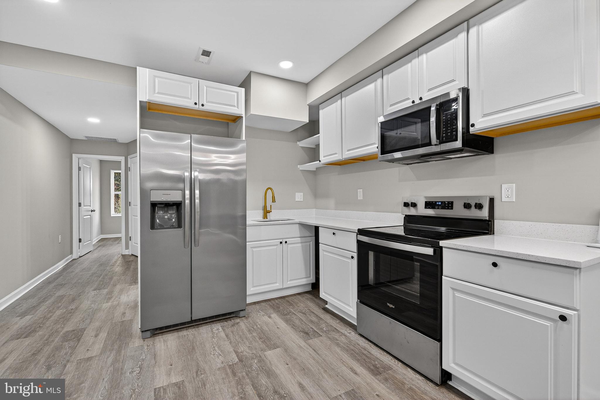 Welcome to 3708 Old Frederick Rd, where classic charm meets ultra-modern luxury. This meticulously renovated home has been reimagined from top to bottom, offering a sophisticated lifestyle for the discerning buyer. Step inside to an open-concept main level defined by sleek finishes and high-contrast accents. The spacious living area features:
Designer Lighting: Striking LED halo chandeliers and recessed lighting throughout.
Modern Feature Wall: A floor-to-ceiling black slat accent wall that anchors the dining space.
Premium Flooring: Durable, contemporary wide-plank flooring that flows seamlessly across the main level. The heart of the home is a masterpiece of functional design, boasting:
Pristine white cabinetry with under-cabinet accents.
Elegant quartz countertops and a matching backsplash.
High-end stainless steel appliances. The bathrooms have been transformed into private sanctuaries. The custom tile work features a stunning mix of marble-veined large format tiles and intricate pebble-stone accents, perfectly complemented by premium gold shower systems and hardware.
Enjoy peace of mind with updated mechanicals and a new stackable laundry center. Spacious rooms with fresh neutral paint and ample natural light. A classic brick exterior with a welcoming front porch and a private rear yard perfect for summer gatherings.
Schedule your private tour today!