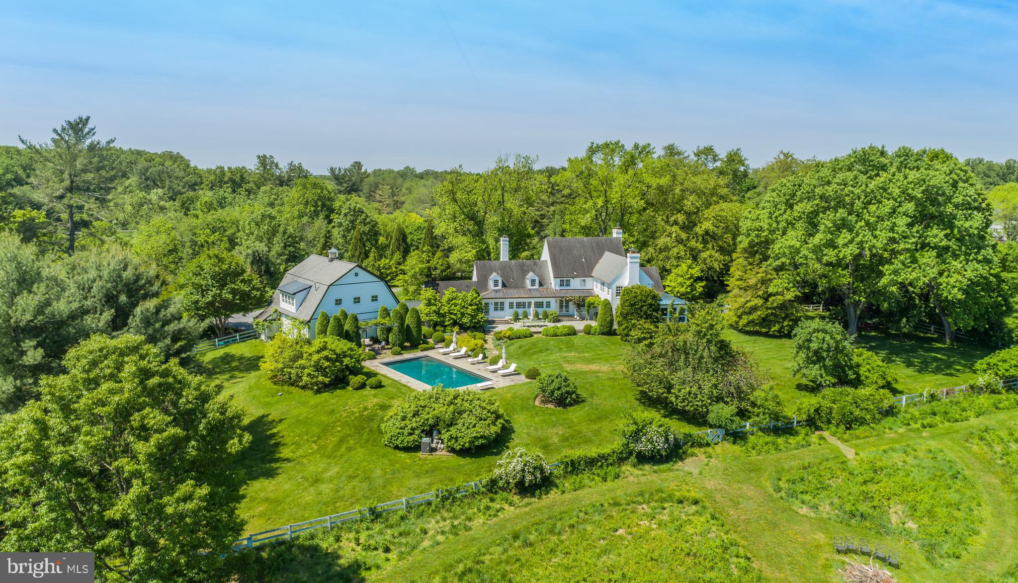 Comprised of two expansive and lush parcels totaling 13.23 acres, 12815 - 12801 River Road is a breathtaking country estate reminiscent of New York’s Adirondacks or the summer residences of The Hamptons. Aptly named as Red Fox Hill, this sprawling manor offers luxury living in a tranquil yet conveniently accessible setting. Solace and serenity abound the manicured grounds, mature trees and rolling hills that encompass the estate, making the property a beautiful respite just outside our nation’s capital. Boasting approximately 10,950 total square feet across 4 levels, the Primary Residence and Carriage Home showcase a combined 6 Bedrooms and 5.5 Bathrooms. Delightful design notes extend throughout the primary residence’s interiors to include gleaming hardwood flooring, magnificent millwork, stunningly coffered and vaulted ceilings, beautiful built-ins, and walls of windows that flood the principal living spaces with natural light. Modern fixtures and amenities elegantly complement the home’s traditional yet timeless architectural accents to offer ease and comfort to today’s style of living. 

Although traditionally appointed, the Main Level floor plan provides a seamless flow between formal entertaining spaces and the more relaxed living spaces. The principal living spaces are located on the Main Level and include the formal Dining and Living Rooms flanking the entry foyer, a more informal Gallery and Study, an exquisite Sunroom, and the sprawling Family Room that opens to both the enviable Screened Porch and the rear Terrace. The expansive Gourmet Kitchen is fit for any caliber chef with a large Island, high-end stainless steel appliances, ample storage space, and a wall of windows overlooking the enviable Terrace and lush grounds beyond. A Breakfast Nook with banquette sits adjacent to the Gourmet Kitchen, providing a more informal dining alternative. Adjacent to the Chef’s Kitchen, French doors open to the rear dining Terrace for idyllic al fresco dining and entertaining overlooking the property’s lush grounds. The Mudroom provides ample storage space and offers breezeway access to the Oversized 5-Car “Car Barn” and Carriage House’s guest quarters that are complete with a fully equipped Kitchen, full Bathroom, and additional storage. The Carriage Home offers incredible views of the property’s enviable 40’ Swimming Pool and Patio, the perfect respite to relax and enjoy the enchanting landscape that surrounds. An en-suite Bedroom completes the Main Level’s offerings. 

The Upper Level showcases 3 of the guest Bedrooms, each offering ample closet space, a hall Bathroom, and the extraordinary Primary Suite. Boasting vaulted ceilings, abundant built-ins, a cozy fireplace, gleaming hardwoods, and bountiful property views, the Primary Bedroom Suite is complete with an expansive walk-in closet and spa-like Bathroom with dual vanities, clawfoot tub, and stall shower. This Suite is truly the ultimate oasis within the residence. 

The multifunctional Lower Level features a Recreation Room, a large Laundry Room with built-ins, and a Full Bathroom. Additional storage space is available on the Top Level. 

From magnificently appointed and stunningly curated interiors to the jaw-dropping outdoor entertaining spaces and impeccably maintained grounds offering lush gardens and greenery, this Colonial country estate is a one-of-a-kind opportunity that is not to be missed.