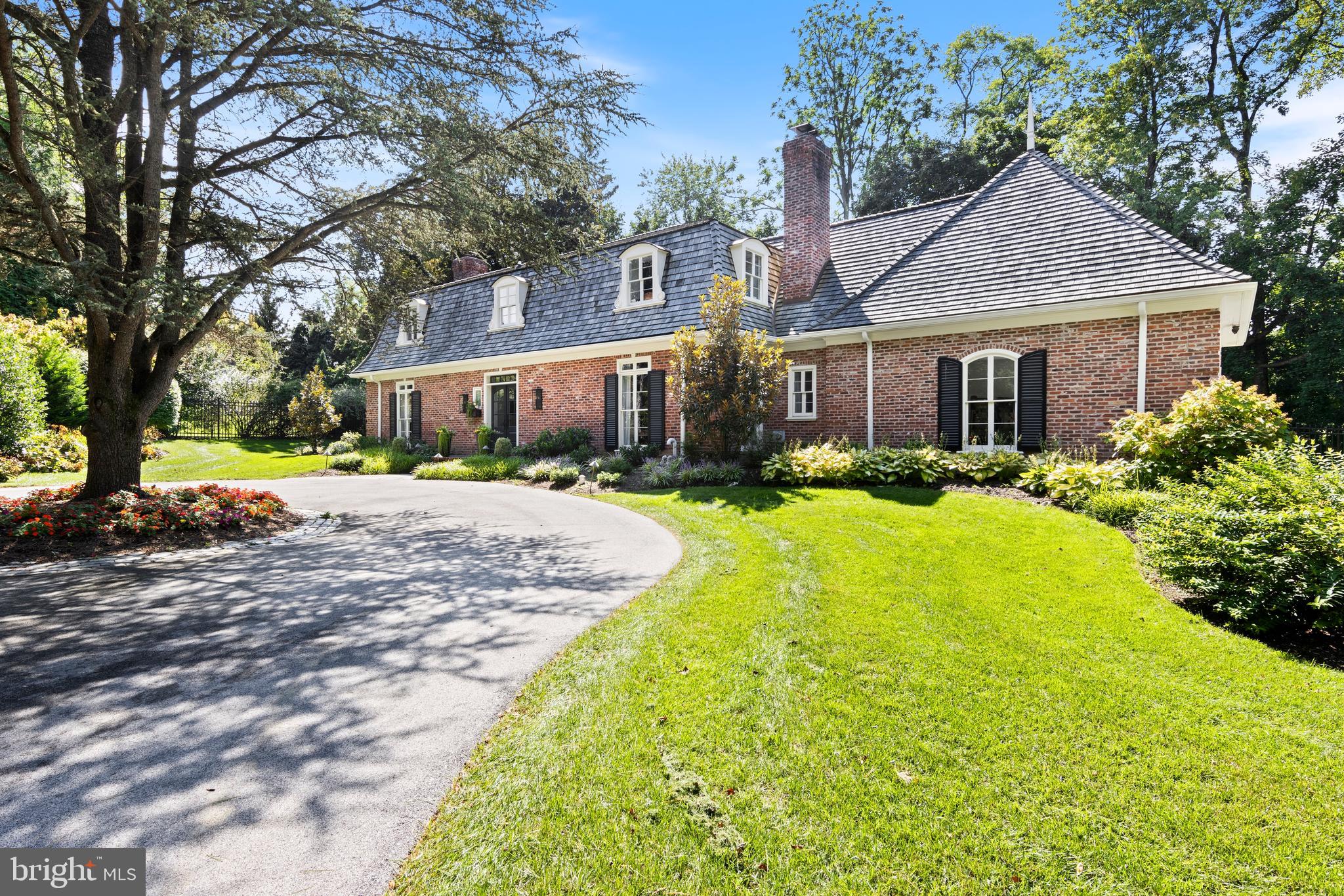 Nestled at the end of a tree-lined driveway, on one of the most coveted streets in Northside Bryn Mawr, this exquisite home with circular driveway offers a life of sophisticated living. Recently completely renovated by PineMar builders, one of the premier builders on the Main Line, this home provides both privacy and tranquility. Upon entering the airy entrance foyer, natural light illuminates the newly renovated spaces through double French front doors, illuminating the newly renovated spaces. The graceful dining room, adjacent to the kitchen, can easily seat family and friends.. The state-of-the-art kitchen, featuring a Sub-Zero refrigerator and Wolf appliances, is ready for culinary mastery.  White cabinets, a large marble island with breakfast bar seating, wine refrigerator and a separate area with large table and chairs complete the space.  The elegant living room, highlighted by beautiful millwork, and a stunning fireplace, exhibits timeless elegance and modern luxury.  French doors lead to a covered patio, seamlessly blending indoor and outdoor living fenced-in backyard, ideal for outdoor gatherings.
The second level is where luxury meets tranquility with four bedrooms and three full bathrooms. The primary suite is a tranquil retreat, with a spa-like marble primary bathroom and walk-in closet. Each bedroom is en-suite with its own bathroom, and two share a connecting bathroom.
This very special home has been reinvented from the new cedar shake roof to the gleaming hardwood floors and custom millwork. This home is a true gem of elegance and luxury.  The location is ideal, close to award-winning schools and major transportation routes, as well as all the shopping and restaurants the Main Line has to offer.