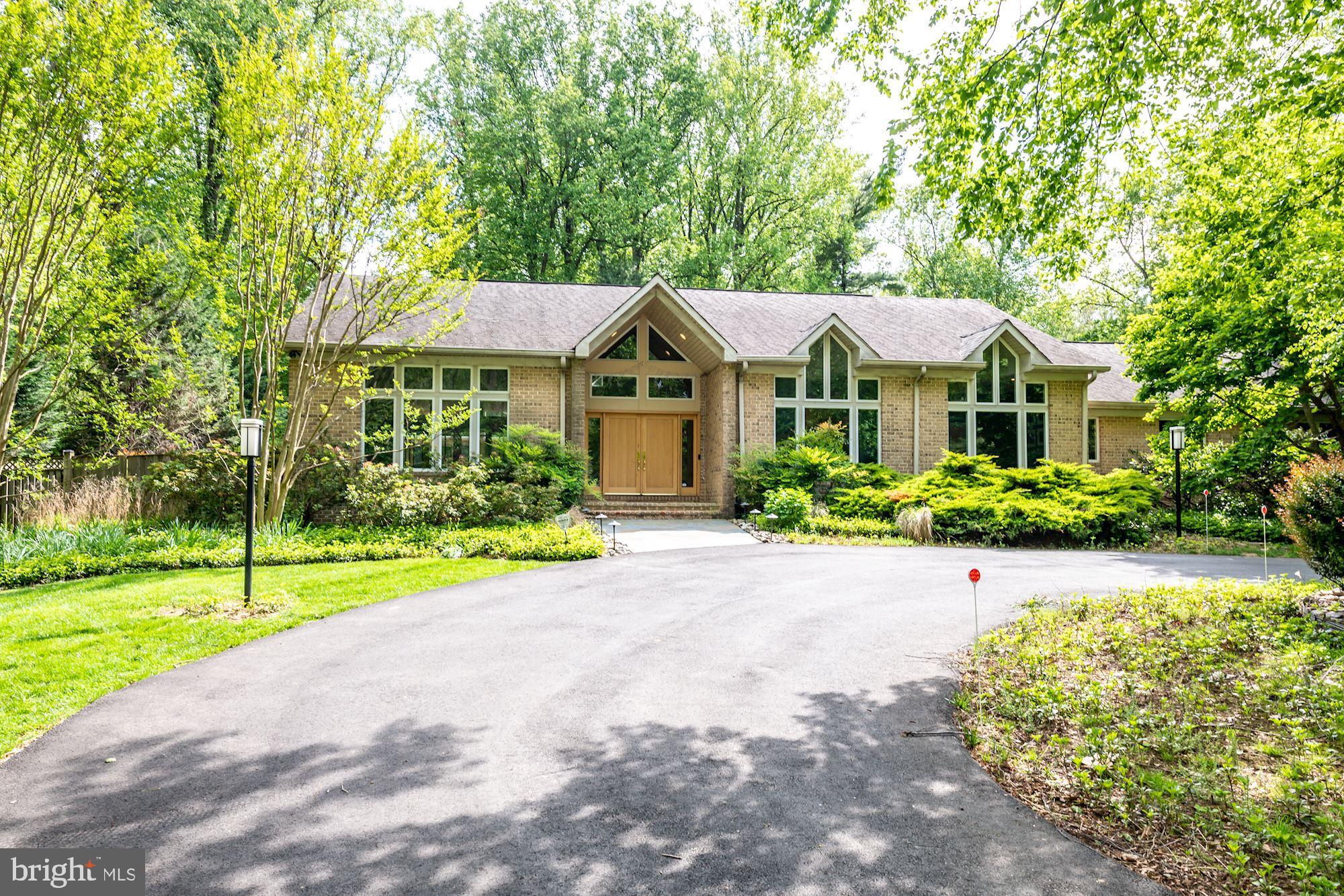Welcome to contemporary living in close-in Potomac. This custom-designed home built  in 2001 features one level living at its best with an adjacent two story  guest house/professional home office both combining outstanding features, high ceilings,  excellent lighting, clerestory windows and the highest quality materials. Beautifully sited on a one-plus, acre lot the fenced backyard provides the perfect setting for a future pool. The recently rebuilt  circular driveway can easily accommodate parking for any size gathering.
The main house has a gracious foyer with a  cathedral ceiling  completely open to the living room and dining room. The living room has two sets of  pocket doors that disappear into the walls giving the option  of making the living room and family one large room. The family room features a wet bar and gas fireplace and a wall  with two sets of  sliding glass doors with peaked  clerestory windows above overlooking the private well landscaped backyard.  The "heart of the home " is definitely the gourmet kitchen .  Expanded in  2013, the space will please the most discerning chef. Exquisite  natural Canadian maple wood cabinetry with custom cabinets and rollout drawers, two ranges, two microwave ovens and a large center island with skylights are just a few of the special highlights. The eating space with its wall of two sliding doors and peaked clerestory windows also overlooks the backyard.
Echoing the high ceilings and windows in the  dining room and family room  is a study or library with a built-in desk with open shelves and cabinets above. The Primary Bedroom with three large walk-in closets and ensuite marble bathroom also access the backyard.  There are three additional bedrooms and two full bathrooms.
The Professional Office/Guest House built in 2013  incorporates many of the wonderful  architectural details found in the main house.  A two story great room  with  spectacular lighting and two sets of sliding glass doors and peaked clerestory windows overlooking the backyard  has a mini kitchen and powder room. Whether  used as an office, guest house or cabana for future pool, this amazing structure with two bedrooms and a full bath on the upper level adds an unexpected dimension to an already wonderful property.
Ideally located close to Potomac Village, this convenient location offers easy access to Virginia,  Washington, D.C. and all major airports.