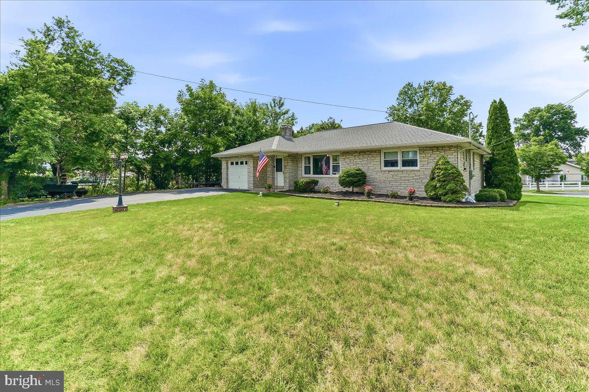 Welcome to 67 1st Avenue, a solid, well-maintained stone ranch offering almost 2,000 sq ft of living space on a beautifully landscaped .51-acre lot in Lower Pottsgrove Township. From the moment you arrive, the lush lawn, mature trees, and charming curb appeal make a lasting first impression.  Inside, the expansive living room stretches over 20 feet and features gleaming refinished hardwood floors, a cozy fireplace framed by a knotty pine accent wall with built-in bookshelves, recessed lighting, and a ceiling fan. Adjacent, the generously sized eat-in kitchen offers plenty of cabinet storage, a large pantry closet, and a gas range with built-in microwave.  All four bedrooms are bright and comfortable, with ceiling fans throughout and hardwood floors in three of the four rooms. The fourth bedroom,  with secondary access from the kitchen, could also be perfect as a home office and features brand new carpeting. The full hall bath has been updated with a fresh vanity and classic tile surround.  Downstairs, the lower level offers far more space than you'd expect - a nearly 700 sq ft recreation room with brand new flooring, recessed lighting, and walk-out access to the backyard. A second full bath with laundry and a large unfinished area ideal for a workshop or additional storage complete the lower level.  Additional highlights include a newer roof (2023), a 1-car attached garage, and a deep, private backyard framed by mature trees. This home has the bones, the space, and the updates buyers are looking for - just move in and make it your own!