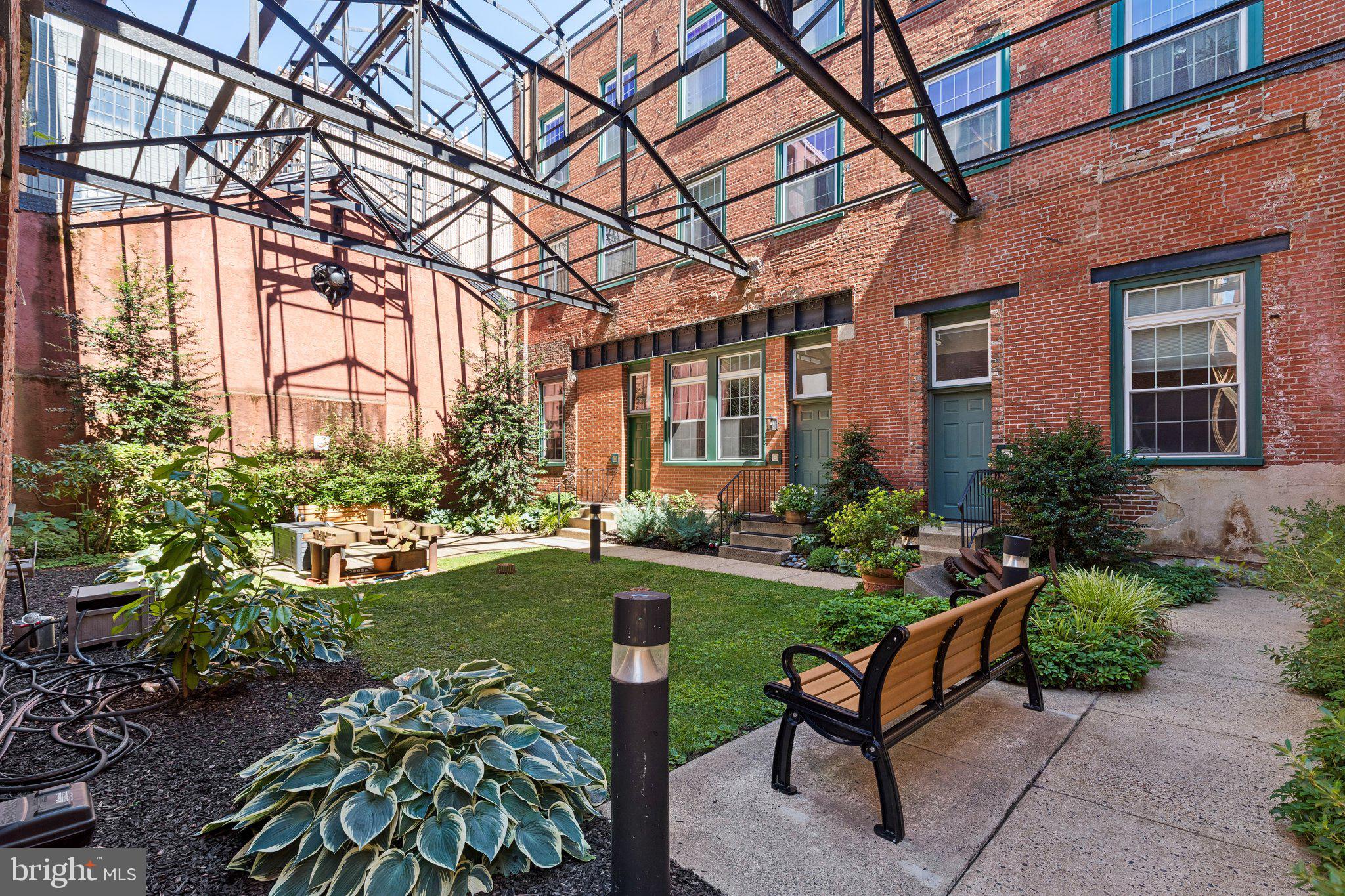 Welcome to The Castings, one of Old City’s most unique and character-filled condominium buildings, tucked away on a charming cobblestone street in the heart of Philadelphia’s historic district. This studio condo at 130-136 N Bread St, Unit 226 offers the perfect combination of location, convenience, and classic industrial charm. Set inside a converted 19th-century former foundry, The Castings immediately makes an impression with its secure entry, dramatic light-filled lobby, exposed brick, original wood beams, soaring atrium-style ceilings, and preserved industrial details that speak to the building’s history.
Inside the unit, you’ll find a smart and functional studio layout with a full bathroom, in-unit laundry, central air, and a comfortable open living space that can easily be arranged for sleeping, lounging, dining, or working from home. The main living area features tile flooring, a large window that brings in natural light, and a built-in ledge/desk area that adds useful everyday function. The kitchen offers wood cabinetry, granite countertops, black appliance package, dishwasher, microwave, cooktop, refrigerator, and additional storage/prep space. A separate entry hall, closet space, and full bathroom with tub/shower complete the interior.
The building itself is a major part of the appeal. Residents enjoy a secure entrance, bike storage, and a peaceful common courtyard surrounded by brick walls, greenery, benches, and preserved industrial pieces from the building’s past — a rare outdoor escape in the middle of the city.
The location is hard to beat. Situated in the heart of Old City, you are just steps from neighborhood favorites, restaurants, coffee shops, boutiques, galleries, gyms, historic landmarks, and the Delaware River Waterfront. Riverwards Produce, Café Ole, 3rd Street shops, Race Street Pier, Penn’s Landing, and some of Philadelphia’s best dining and nightlife are all nearby, while public transportation and major roadways make getting around the city easy. Whether you are looking for a primary residence or an investment opportunity, Unit 226 at The Castings delivers historic charm, everyday convenience, and one of Philadelphia’s most walkable locations.
