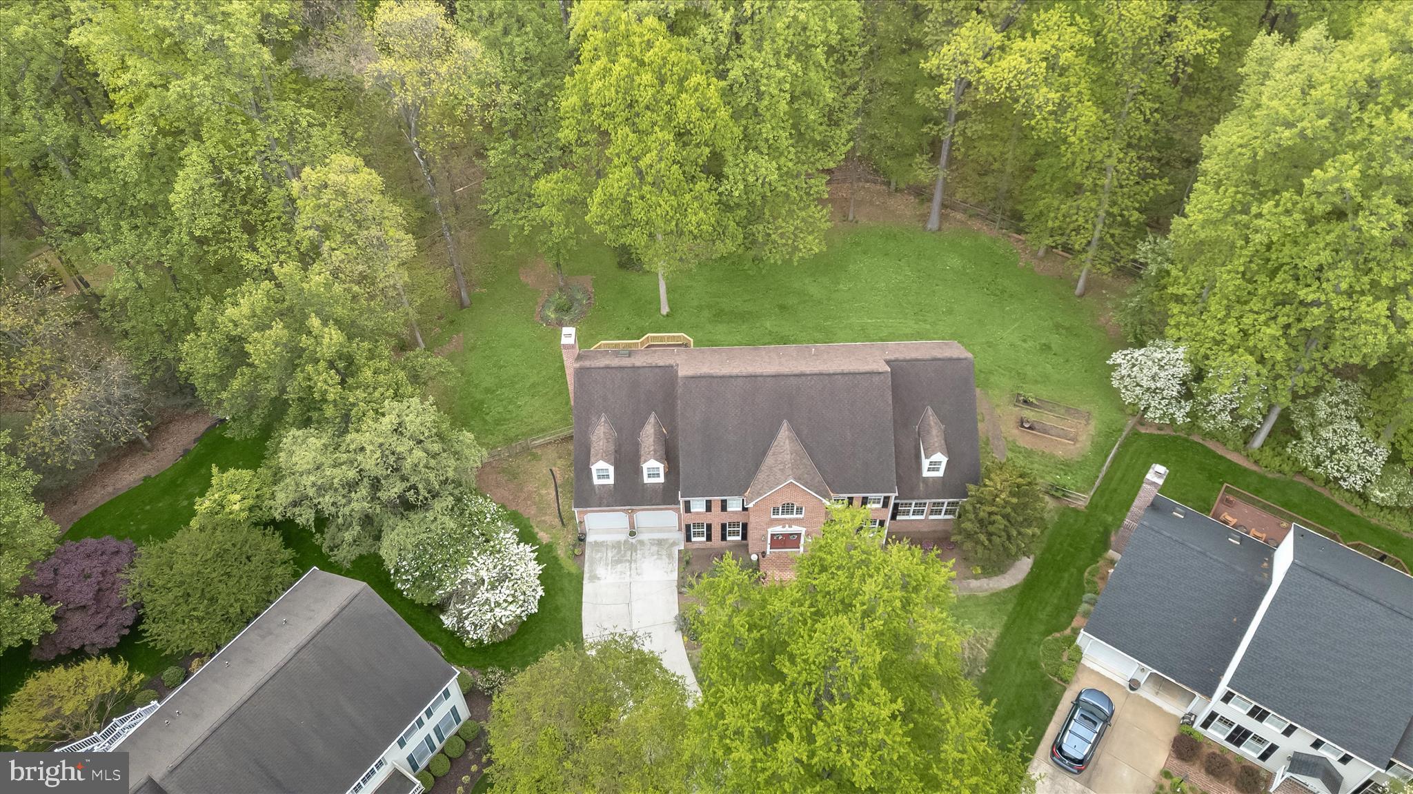 Exceptional brick colonial nestled in the prestigious and private King’s Contrivance enclave of Columbia, offering refined living on beautifully landscaped grounds.  Set on .63 acres, the property boasts manicured landscaping and a fenced backyard that opens to permanent open space with the potential for a pool, creating a private and picturesque outdoor setting. A striking French door entry introduces a dramatic two-story foyer adorned with a Palladian window, crown molding, chair railing, and elegant box wainscoting, setting the tone for the home’s timeless sophistication.  Gracious formal living and dining rooms are designed for elevated entertaining, each enhanced by rich hardwood flooring, detailed millwork, and refined accents. The dining room’s bay window and wall sconces create a warm, ambient setting. At the same time, an adjoining flex/game area offers versatility and seamless access to the screened-in deck, perfect for effortless indoor-outdoor gatherings.  The gourmet kitchen is thoughtfully appointed with a center island, peninsula breakfast bar, abundant cabinetry, and sleek appliances, flowing into a sunlit breakfast room and an inviting family room. Here, a brick-surrounded wood-burning fireplace, custom trim, and deck access provide a comfortable yet elegant retreat overlooking serene natural surroundings. A private office with custom built-ins and a well-placed powder room complete the main level.  Upstairs, the luxurious primary suite serves as a true sanctuary, featuring hardwood floors, a spacious sitting room, dual walk-in closets, and a spa-inspired bath with double vanity, jetted soaking tub beneath a skylight, and a separate walk-in shower. Four additional generously sized bedrooms and two full baths offer ample accommodations.  The fully finished lower level presents exceptional flexibility with a private entrance, full second kitchen, living and dining areas, bonus space, and a bedroom suite, ideal for multigenerational living, guests, or upscale entertaining. Conveniently located near major commuter routes, including I-70, US-29, and MD-32, with easy access to premier shopping at The Mall in Columbia, world-class performances at Merriweather Post Pavilion, and community amenities within the Huntington/Dickinson neighborhood.