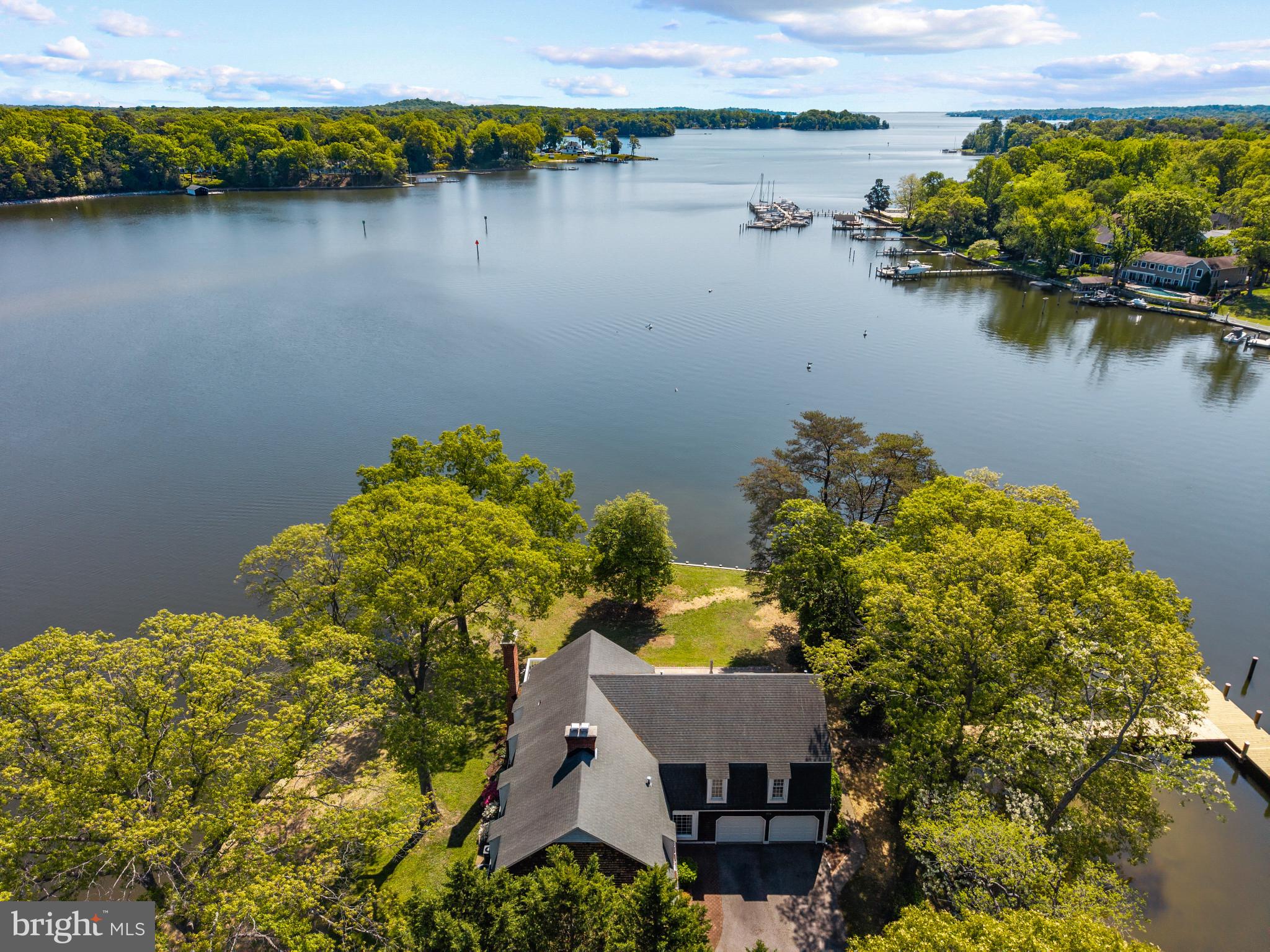 Set on a spectacular point of land along the Magothy River, this rare offering captures panoramic water views in every direction and delivers the kind of waterfront lifestyle that is increasingly hard to find. With an extraordinary 497 linear feet of shoreline, upgraded bulkhead, and a newly constructed pier, the property is wrapped in water, creating a sense of privacy, openness, and connection to the river that defines every moment here.

The new private pier extends into deep, protected waters with the capability to accommodate a large vessel, making this an ideal setting for boating enthusiasts eager to explore the Magothy and beyond to the Chesapeake Bay. Whether it’s early morning departures, sunset cruises, or effortless days spent on the water, this property is designed to fully embrace life on the river.

Inside, the home offers a warm and inviting layout with expansive living spaces that frame the ever-changing waterfront backdrop. The kitchen and adjoining dining area are perfectly positioned to take advantage of the views, while multiple gathering spaces—including a wood-clad great room with fireplace and a sun-filled waterside porch—create a seamless flow for both everyday living and entertaining. Classic detailing, rich wood floors, and timeless finishes provide a strong foundation ready to be enjoyed as-is or elevated to suit your vision.

The upper level features a spacious primary suite highlighted by a private balcony overlooking the water, an ideal retreat for quiet mornings and peaceful evenings. Additional bedrooms offer comfortable accommodations for family and guests, many with their own unique vantage points of the river.

Outdoor living is equally compelling, with a waterside deck, expansive lawn, and mature trees framing the shoreline. The setting invites everything from casual gatherings to large-scale entertaining, all with the Magothy River as your backdrop.

Adding to its exceptional appeal, this remarkable property offers a rare combination of features seldom found in waterfront homes, including the coveted waterfront trifecta of public water, public sewer, and natural gas — an invaluable advantage that provides both everyday convenience and long-term flexibility. Situated just steps from the community pool in the highly sought-after Fair Oaks on the Magothy community and within the Severna Park Blue Ribbon school district, the property seamlessly blends an extraordinary point-of-land setting with an unmatched waterfront lifestyle centered around boating, relaxation, and year-round enjoyment on the water. Welcome Home!