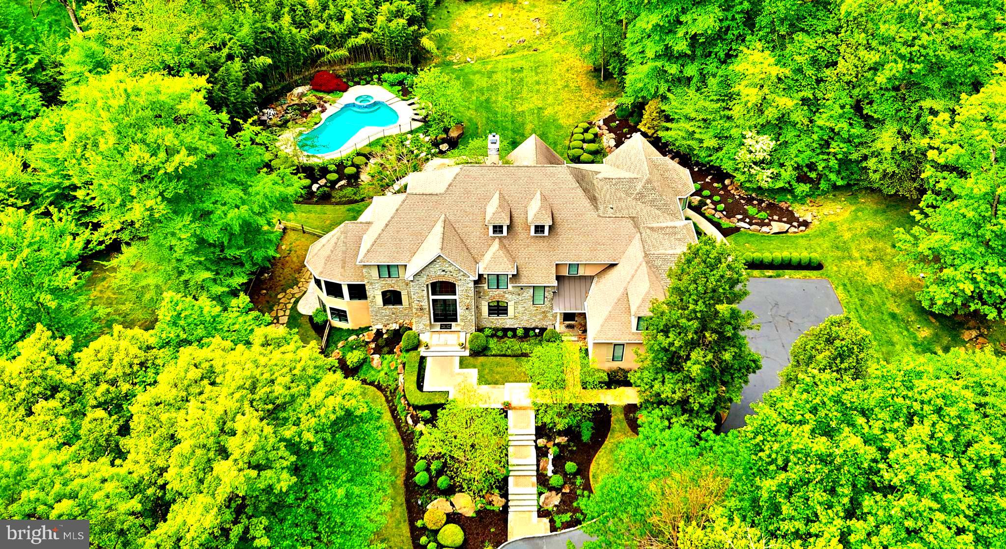 Be prepared to be impressed by this exquisite custom built home in Upper Makefield’s most prestigious location and premier neighborhood. Sited perfectly on over 5 acres with Jericho Mountain as the backdrop, this estate property was wonderfully crafted by Richard Zaveta in 2002, and further enhanced with an expansion in 2012 by Mack and Roedel, the two “Rolls Royce” builders in the area. This distinguished property features one of a kind architectural elements both inside and out, and is in immaculate mint, move-in condition. Standing majestically at the top of a 250 foot driveway, the home features one of the most stunning and dramatic Gourmet Kitchens and Primary Suites you will encounter in today’s market. The perfectly scaled and laid out rooms, expansive finished lower level, pristine pool, and manicured grounds make for a property precisely what you would expect in this highly sought after neighborhood of just 23 custom homes on larger lots, sprinkled throughout two cul-de-sacs. A dramatic two story foyer entry reveals a beautiful classic staircase with traditional white balusters, gleaming hardwoods, generous amounts of spectacular detailed millwork, ample natural light and a smart, comfortable floor plan. The main floor features an award winning kitchen with a 220” center island, multiple sinks and prep areas, highest end appliances such as Wolf oversized 6 burner double oven range, separate 36” Sub Zero refrigerator and freezer, Miele cappuccino machine, quartz counters, intricate box beamed ceiling, walk in pantry and more. Three sets of French doors open to the rear serene oasis featuring a huge patio, outdoor kitchen and in ground pool, all in a very quiet, tranquil, private setting. The adjoining family room boasts a double sided gas fireplace, shared with the dramatic two story living room, also featuring patio access. A cozy library retreat, large conservatory / office with walls of windows and cathedral ceiling, formal dining room with custom cabinets, large laundry room w/ outside access, and two powder rooms complete the main floor. The upper level has an extra wide hallway with overlook to the family room, convenient rear staircase, and is flanked by large bright and airy bedrooms (Bedroom 5 is currently used as a upstairs family room), all with huge closets, and ceiling fans. The incredible Primary Suite has a tray ceiling, giant sitting room with vaulted ceiling, his and hers walk-in closets and exquisite bath with walk in shower, free standing tub, heated floors, and private toilet closet. The walk-out finished lower level has spacious bedroom 6 and full bath w/ steam shower, entertainment area, workout area, kitchenette, craft room, and ample storage space. Other features of this magnificent home are a whole house generator, central vacuum, three car oversized garage, multi zone HVAC, security system, irrigation, and more. This premier community, with NO HOA, is just minutes from New Jersey bridges, New Hope, Newtown, Washington Crossing, I-295/95; 90 minutes to NYC and 45 minutes to Center City Philadelphia. Offered by the original owners, this is an enchanting opportunity to acquire a remarkable estate property in the heart of the Council Rock School District.