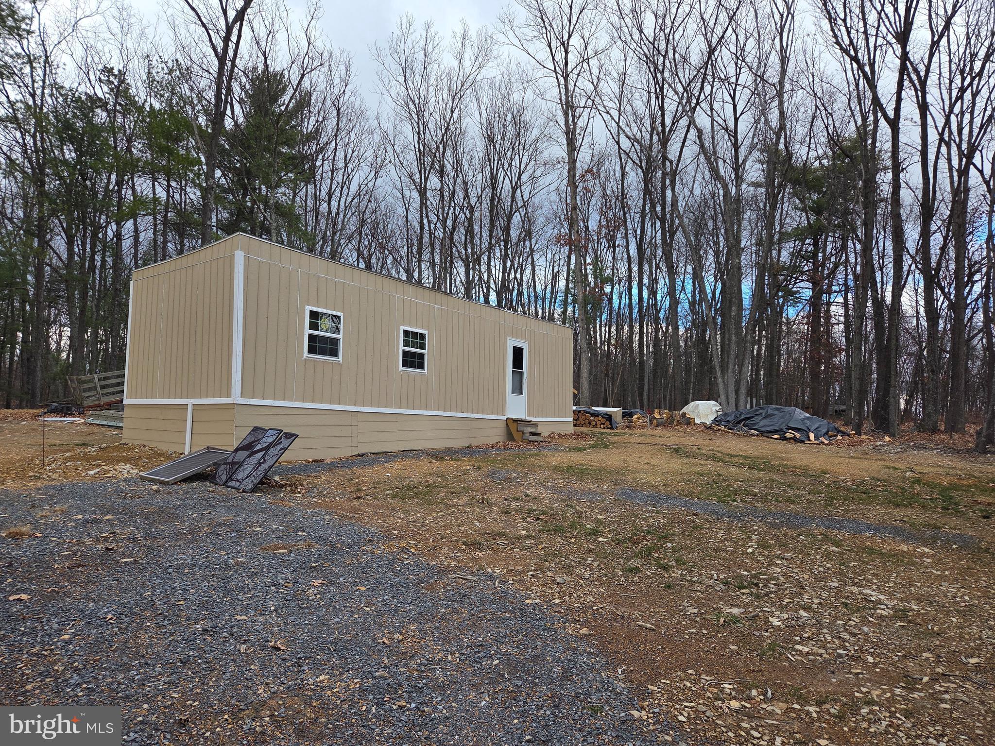 Nice flat buildable 2.95 acre lot. Partly wooded and a cleared spot with a 12x36 shed currently being converted into a tiny home that includes an open floor plan, full bath, kitchenette, living room and bedroom, R13 insulation and 3" foam insulation as part of the underpinning, and a wood stove to keep you warm.  All of the building materials, paint, extra insulation are waiting for you to finish and make livable while you build that forever home. Well and septic are already installed so half of the work is already complete. 220 Amp electric service is in the building as well as a hookup on the pole just in case you wanted to pull in a camper while you build. All appliances do convey. All new plumbing and fixtures. The metal roof has been coated as extra protection against the weather. There are covenants/restrictions uploaded but seller reports no HOA dues are paid. Community residents maintain road. Property is being sold as is.