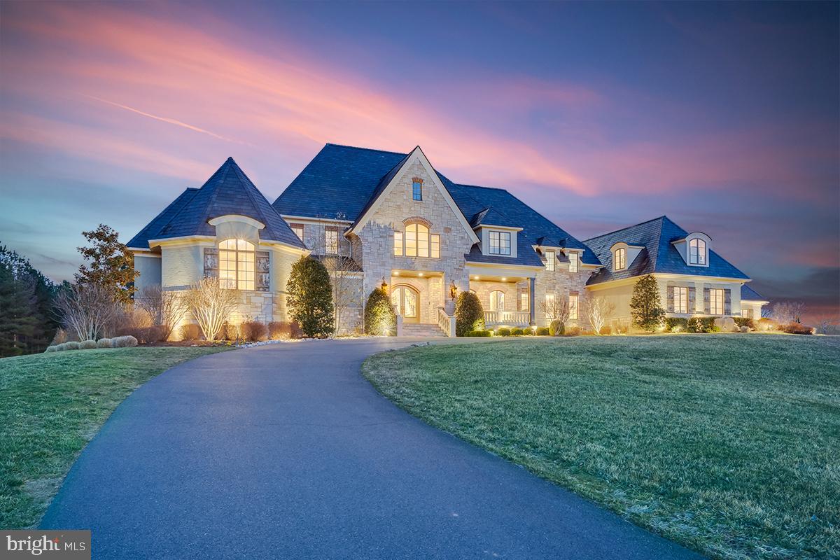 22662 Creighton Farms Drive is a remarkable residence that is perfectly situated on a spectacular lot that is comprised of 8 Bedrooms, 7 Full Baths, 3 Half Baths, and an attached 3-Car Garage, plus breezeway to an additional 2 car garage. This peaceful, estate-like home rests on 3.32 acres in Leesburg VA and features exceptional living spaces and a fantastic location minutes to Ashburn and the future Silver Line Metro. This home showcases elegance with its oversized windows, intricate millwork and moldings, and well-proportioned rooms. Warm and inviting, the wide Foyer reveals views that span from the front door to the rear Patio. Natural light touches every room and transforms this home into a serene estate nestled amongst Creighton Farms World Class Golf Course. Off of the Foyer to the left is an art gallery and music room.  To the right off the foyer is a light filled hall leading to the dining room with a wet bar and wine rack. Through the Foyer, there is a spacious Family Room with a fireplace, and access to the rear Patio. The main level Master Bedroom is fit for a King, private balcony and fireplace with a walk-through from the balcony to your own private office.  His and Hers Walk-in closets with custom built in shelving and spa like luxury bath.  Spacious and well-designed, the Kitchen is outfitted with nearly everything that any Chef would desire. Off the Kitchen is a Gathering room with large open Fireplace and a Kids study work space.  The Upper Level sequesters 4 Bedrooms and 5 Full Baths, all versatile enough to be used as Private Bedrooms, Guest Rooms, an Au-Pair/In-Law Suite, or a secluded upper level workspace. The Second Level Master Suite encompasses a large play area in what used to be an attic space and luxury Master Bath. An extensive second level Family Room is convenient and offers lovely views of the butterfly staircase and gold course. There is also a loft, wet bar area and craft room over the garage that could be used as another bedroom.  The lower level offers 2 additional bedrooms, 1 Full Bathroom, 1 Half Bathroom, Gym, Sport Court, Finished Office that can be converted into a caters kitchen, Media Room, large recreation room with Fire Place and Full Bar with Dishwasher.  Large Stone Patios Round out both the lower level and main level for the finest outdoor entertaining.