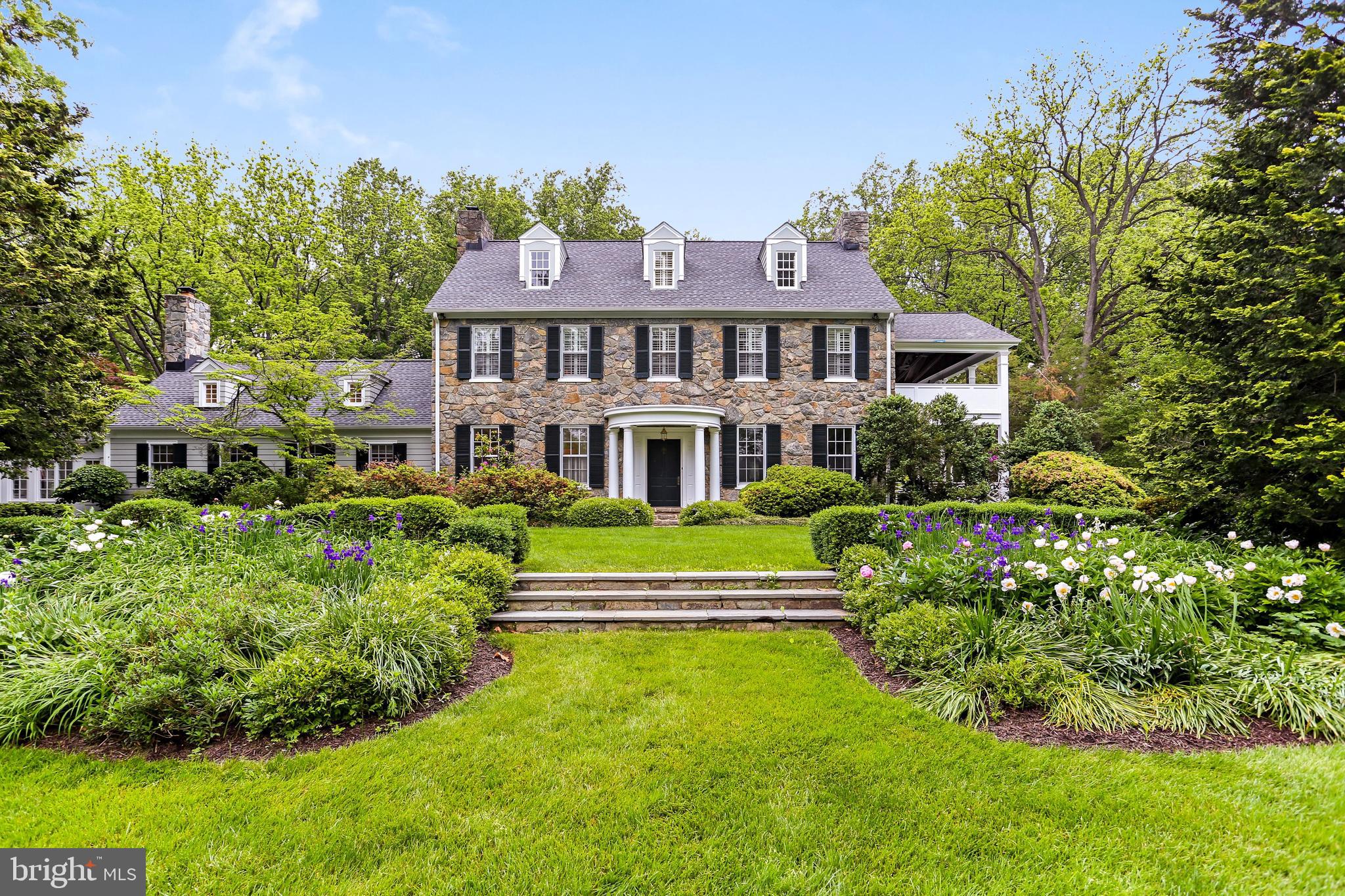 Prepare to be enchanted with this gracious stone estate in one of McLean’s most sought-after neighborhoods. The original home built in 1932 has high ceilings and grand spaces with charming porches. It was thoughtfully expanded and renovated by the highly acclaimed architect, Ankie Barnes of Washington DC. This meticulously maintained home is sited on a sprawling, flat and sunny 2 acres with mature landscaping that surrounds the luxurious pool offering complete privacy. A warm and inviting Foyer welcomes you to the formal Living Room with cozy fireplace and French Doors that provide access to the oversized porch with ceiling fans overlooking the pool. The banquet size Dining Room with fireplace is great for entertaining. A Chef's Kitchen open to the Family Room awaits with high beamed ceilings, center island, skylights, top-of-the-line appliances, walk-in Pantry and Breakfast Room with exposed stone from the original house. The Family Room has custom built-ins around a stone fireplace and 2 sets of French doors to access the rear Patio with a Pergola. The Upper Level boasts the Owner’s Suite with a walk-in closet, doors to a private terrace with garden views, luxurious Bath with double vanities and steam shower. There are also two Bedrooms and Bath on the Upper Level and a Third Level with two additional Bedrooms and a large Bathroom. The Lower Level has an Exercise Room with built-ins, custom Wine Cellar and plenty of storage room.  A breezeway connects the Main House to the two-car Garage and there is a lovely Guest Apartment with a full Bath above the Garage. Only minutes to DC, MD, Tyson, I-495, GW Parkway and downtown McLean this special property is truly one-of-a-kind