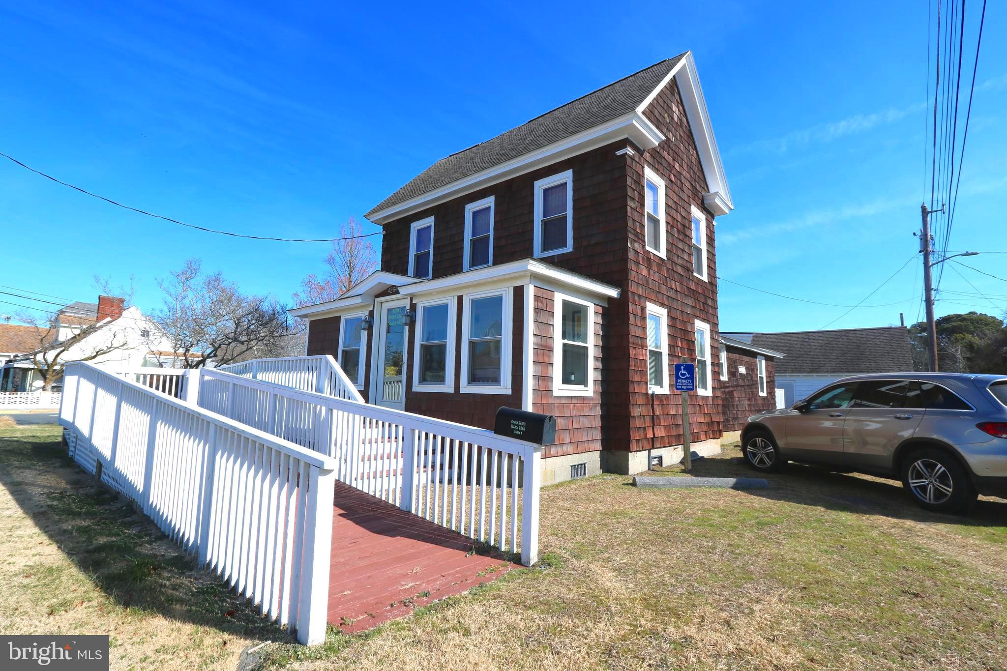 Motivated Seller and Another Huge Price Reduction! Positioned on one of the most visible and desirable corners on Chincoteague Island, this fully renovated mixed-use property at Ocean Blvd and Main Street offers exceptional flexibility, income potential, and long-term value. Zoned C-2 commercial, the property is ideal for retail, office, restaurant, or service-based business use, while also allowing for residential opportunities. The first floor currently operates as commercial space but can be easily converted into a second apartment or short-term rental, creating multiple income streams under one roof. Upstairs, a charming 1-bedroom apartment features water views and abundant natural light — perfect for an owner’s suite, long-term tenant, or vacation rental.
Additional highlights include a detached garage for storage or workspace, an enclosed porch, and a large deck ideal for relaxing or entertaining. Fully renovated in 2012, the building blends modern updates with island character, offering low maintenance and turnkey appeal. With premium corner exposure, strong foot and vehicle traffic, and flexible C-2 zoning, this property is a rare opportunity to live, work, and invest in one of Chincoteague’s most sought-after locations. Septic system is rated for 3BR.