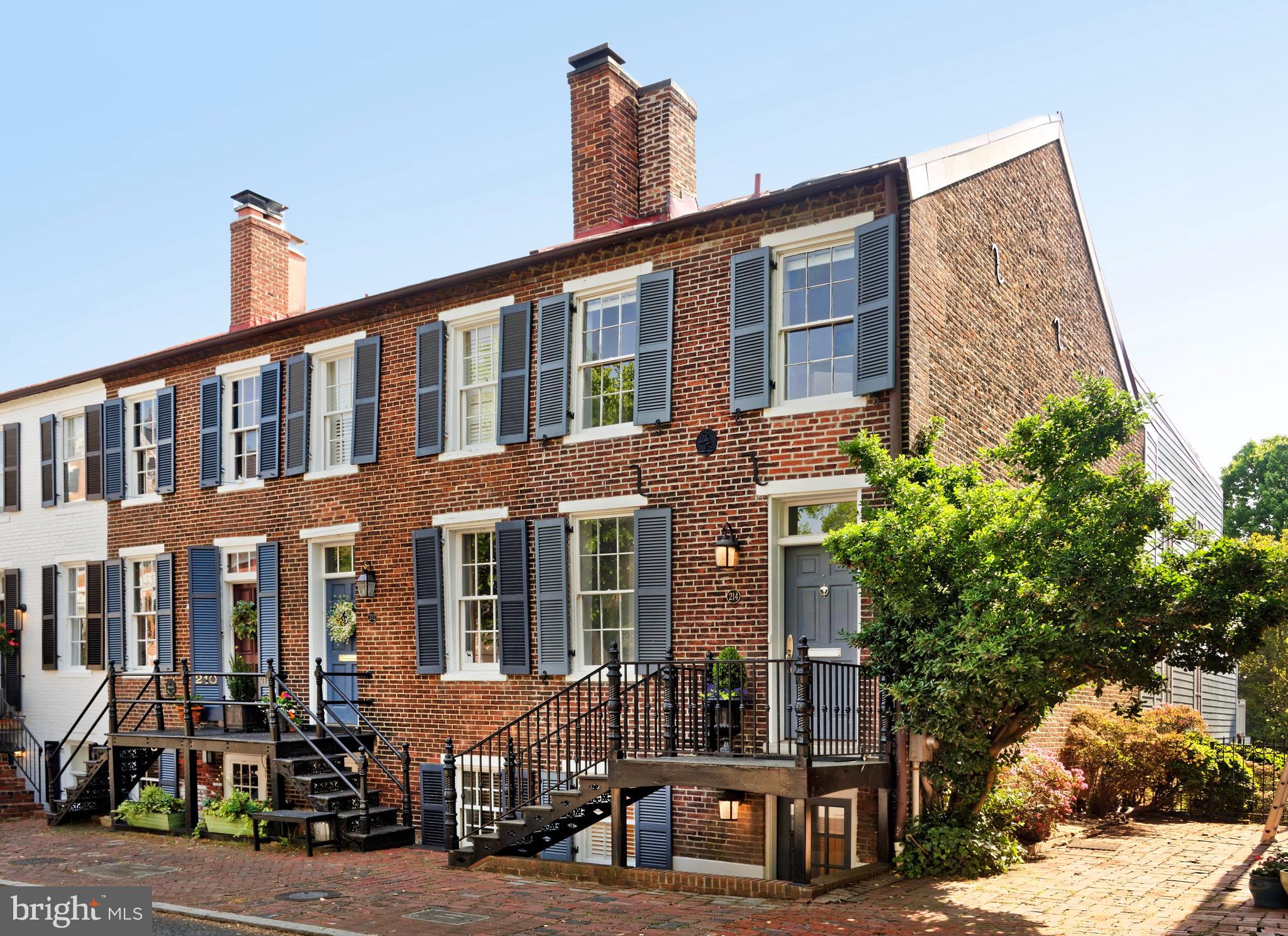 Spectacular in every way, this wonderful 1820-built 3 bedroom 3.55 bath townhome offers a beautiful addition and is totally updated for modern tastes.  Enchanting classic touches enhance the warmth and graciousness of 214 South Lee Street, including original heart pine floors which have been refurbished and replaced, two  fireplaces with gas logs, custom  built-in shelving and cabinetry, an exposed brick wall plus tasteful crown moldings that add the air of elegance.  Because the home is semi-detached, with many windows plus glass French doors  on all levels,  it is brightened by a generosity of sunlight.   This absolute beauty also offers contemporary features such as stainless appliances, granite counters, two kitchen sinks and  two outside entrances on this kitchen floor.   The living room features a wet bar and mini refrigerator,  a splendid fireplace surround and distinctive bookshelves.  The dining room is gracious and a perfect place to entertain with a wine cooler nearby.  You'll enjoy spacious, elegant bedrooms with customized closets and two pairs of French doors leading to two outdoor decks with awnings.  The primary suite features a generous room with high ceilings, radiant in-floor heating in the bathroom, its own washer/dryer and an enormous walk-in closet.   While the interior is fabulous, the outdoor area is as appealing and rare to find in Old Town.  The outdoor porch with columns and a wood ceiling is private and  perfect for reading or enjoying a glass of wine.  A tranquil  patio offers space for dining al fresco and the dog can lie on the green grass beyond.    Do not miss this remarkable home on coveted  South Lee Street near restaurants, shops, the waterfront and parks!